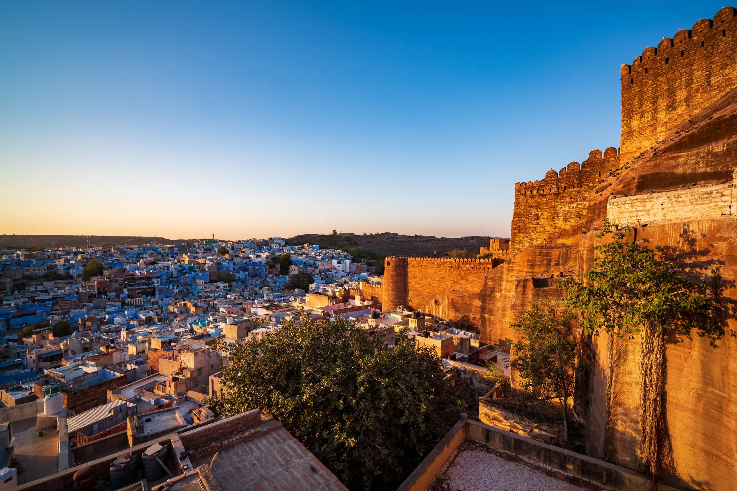 Mehrangarh Fort rising above the blue houses of Jodhpur at sunset