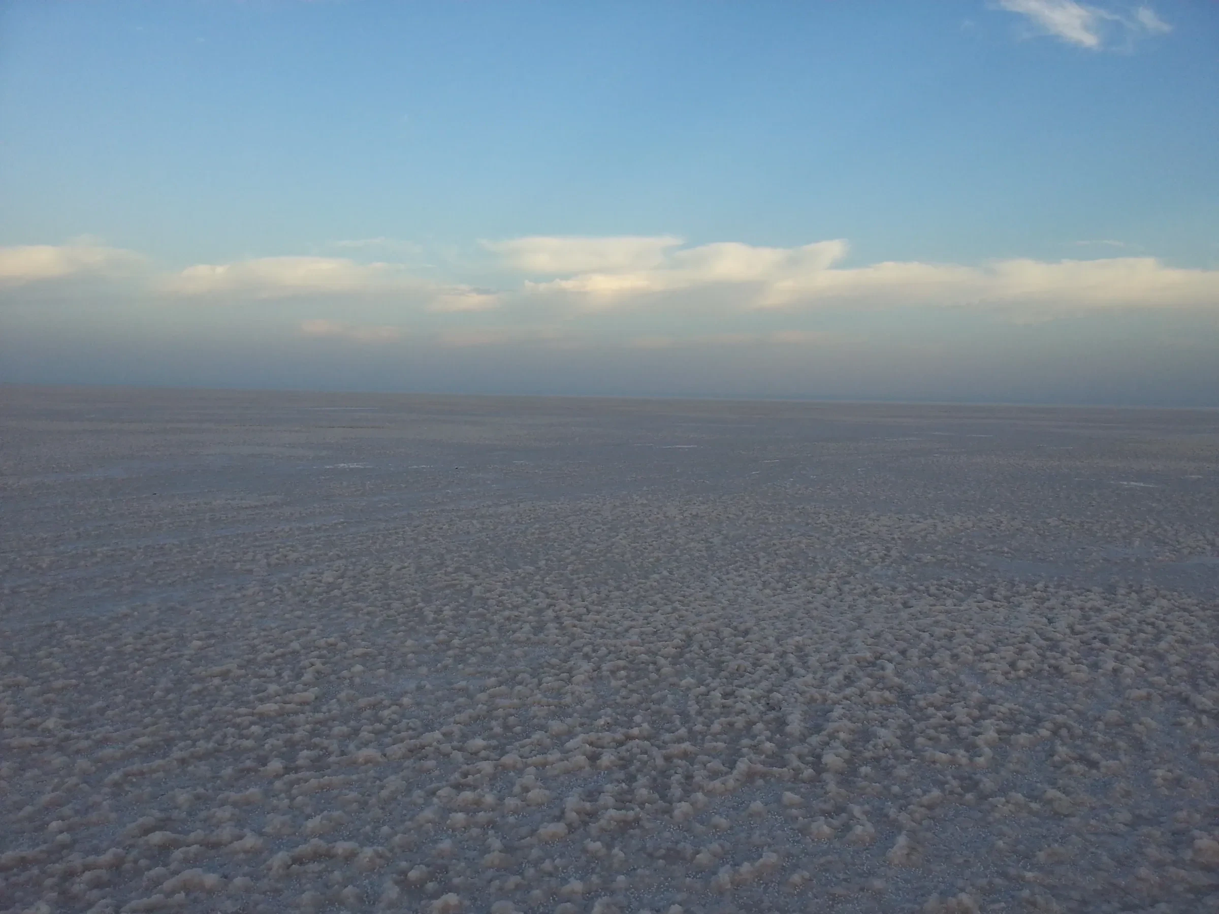 The White Rann's pale salt crust under a hazy blue evening sky