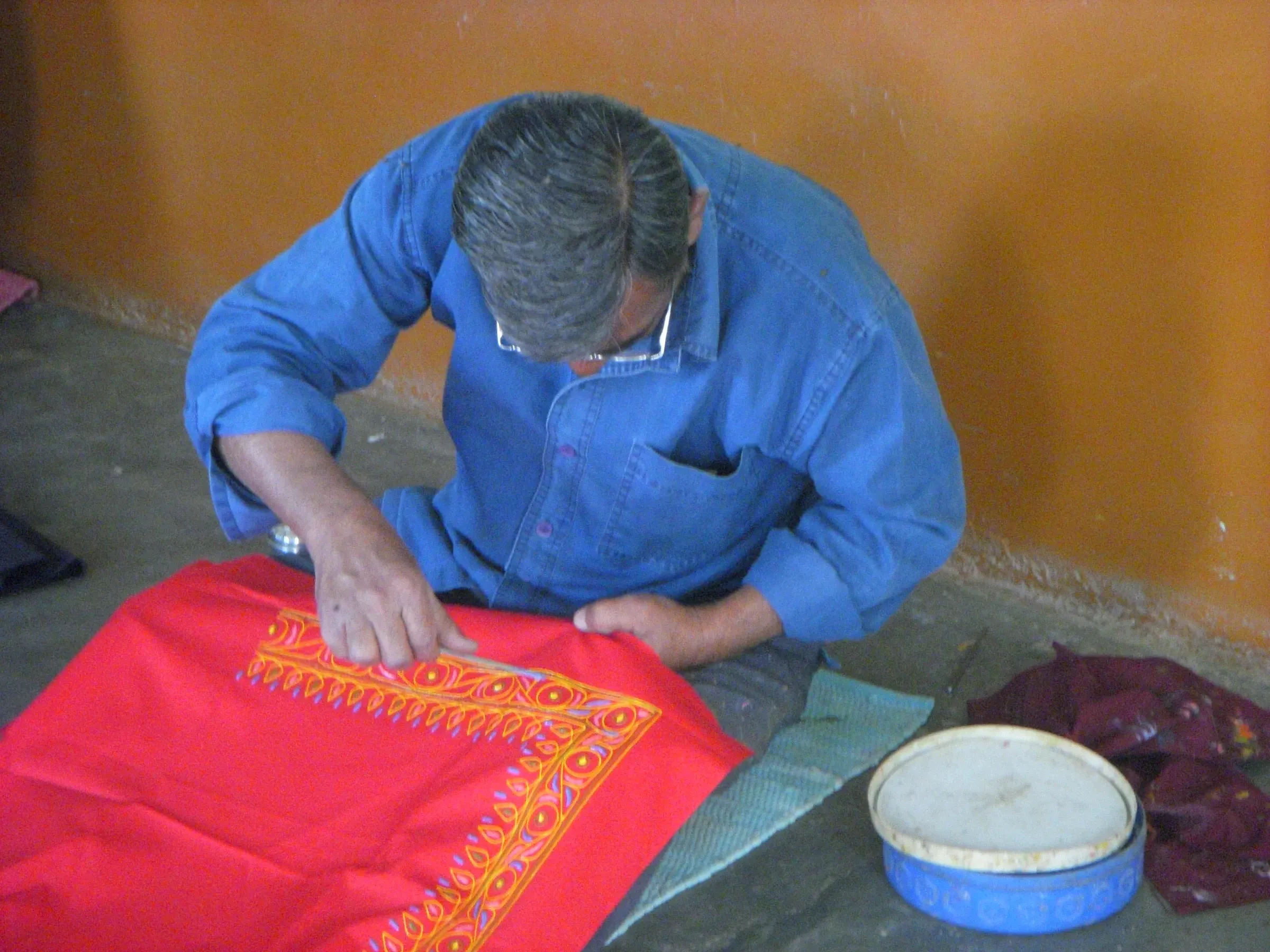 A craftsman painting Rogan art on cloth in the village of Nirona, Kutch
