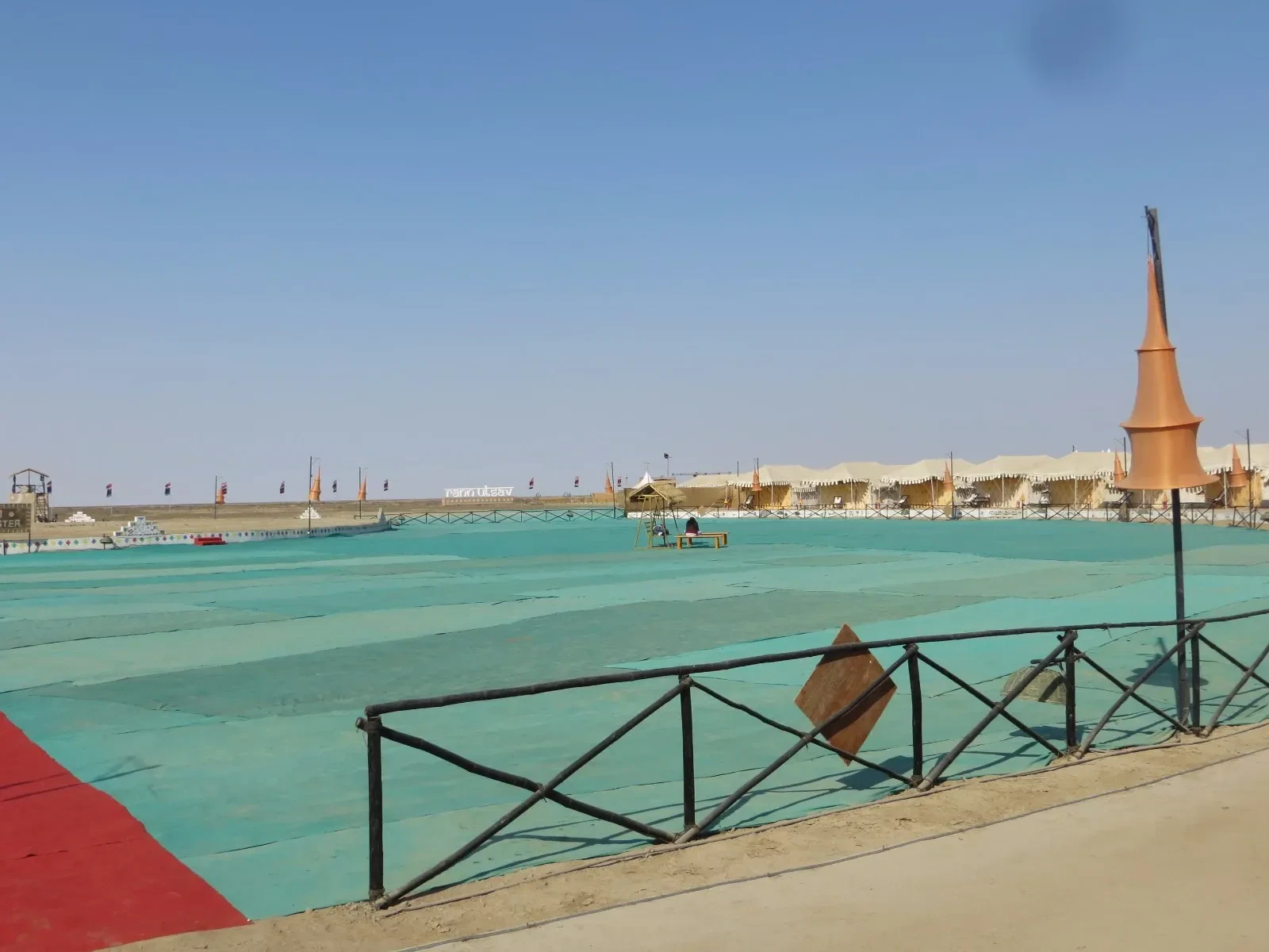 Rows of white tents beside the open venue ground at the Rann Utsav tent city