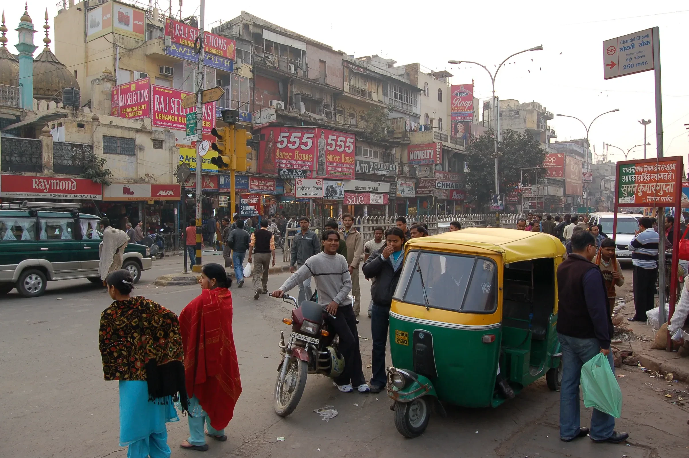 A busy street in Chandni Chowk, Old Delhi, with an auto-rickshaw, pedestrians and shopfronts