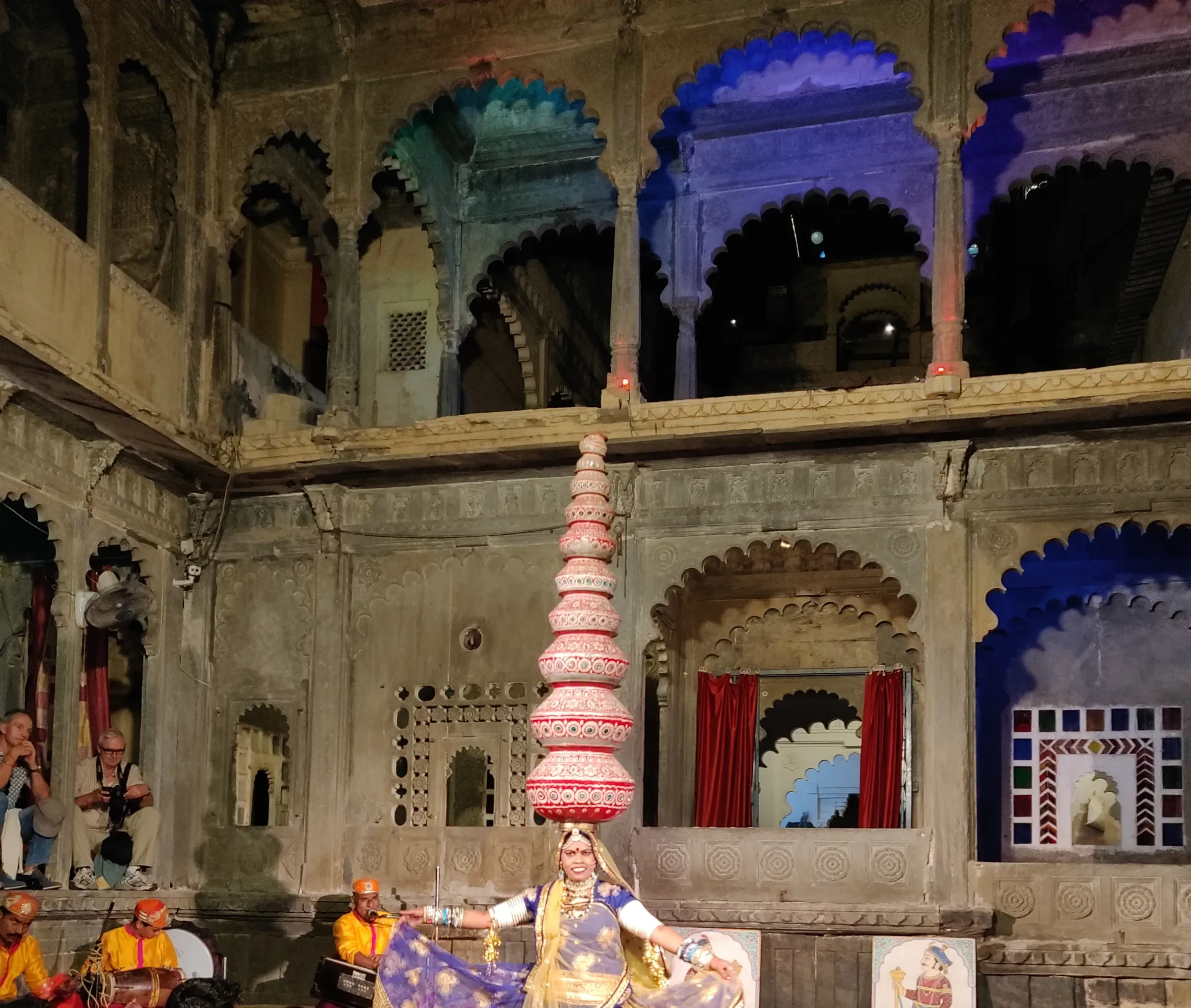 A Rajasthani folk dancer balancing stacked pots at Bagore Ki Haveli