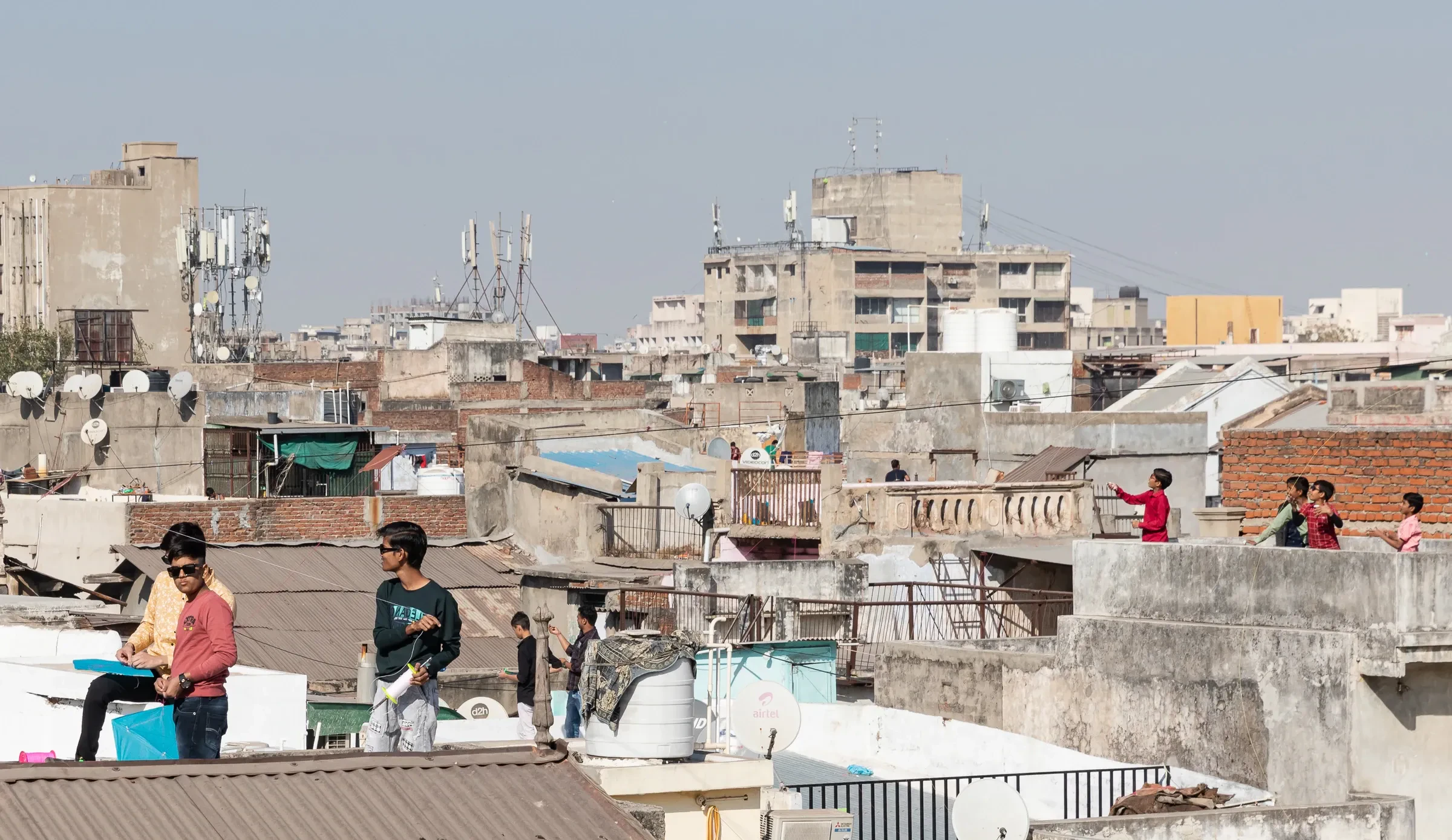 Rooftops in Ahmedabad's old city, with people flying kites from the terraces