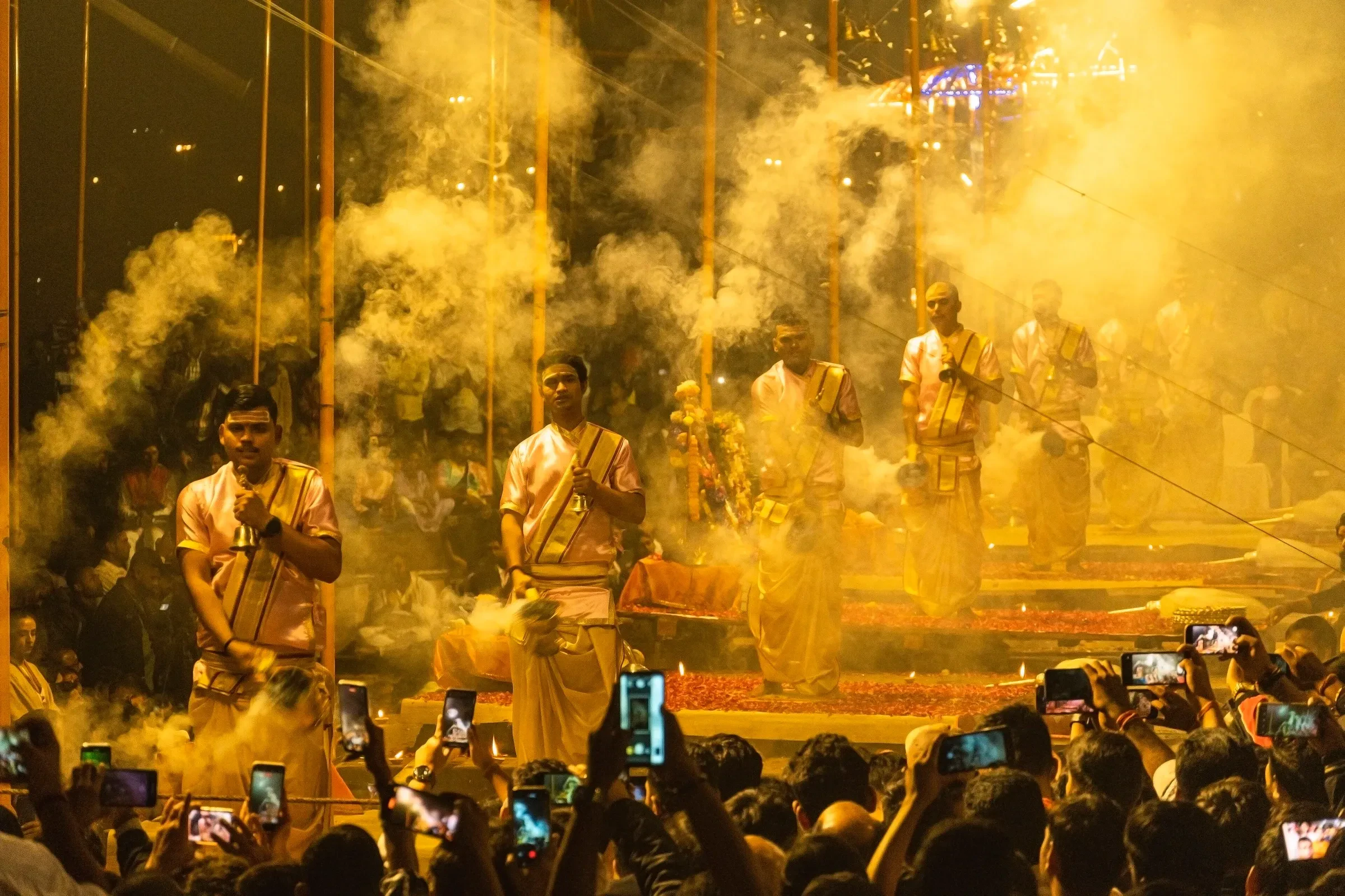 Priests and a crowd with phones during the evening Ganga aarti in Varanasi