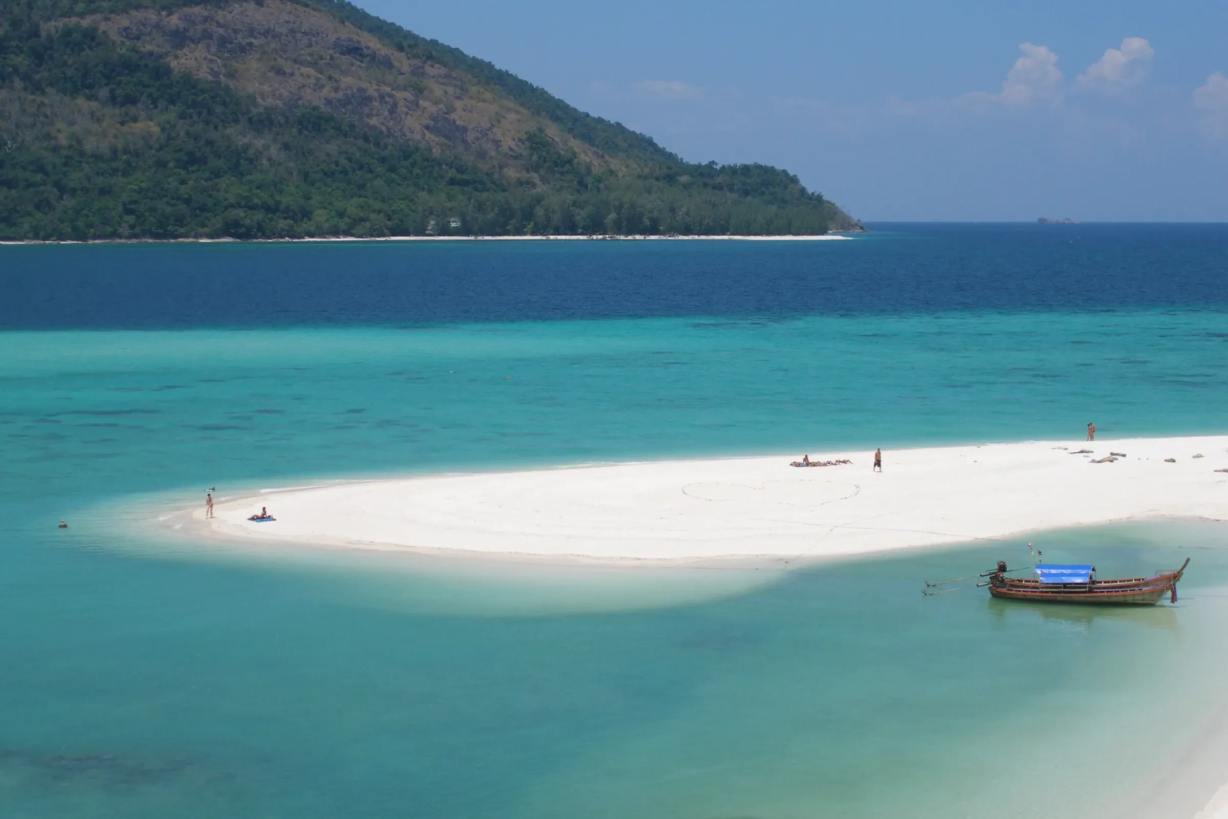 A longtail boat off a white sandbar on Koh Lipe, Thailand