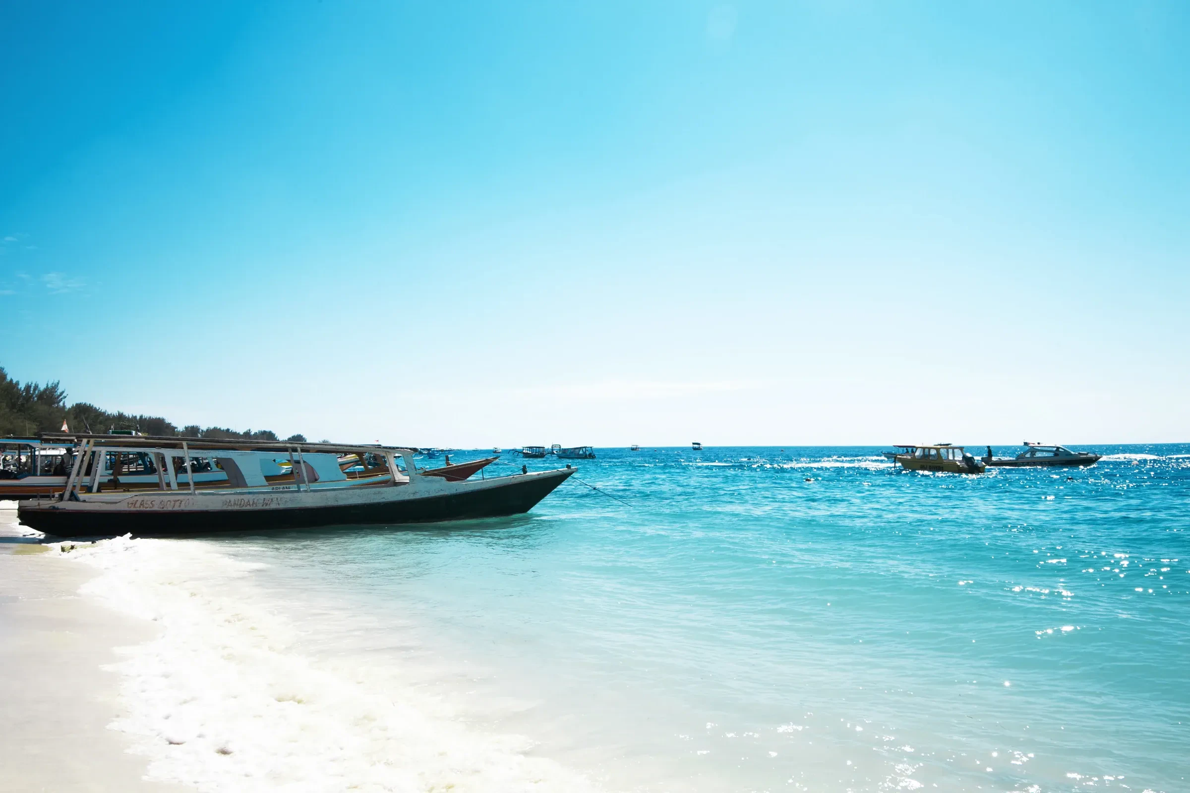 Boats waiting close to the white-sand shore on Gili Trawangan