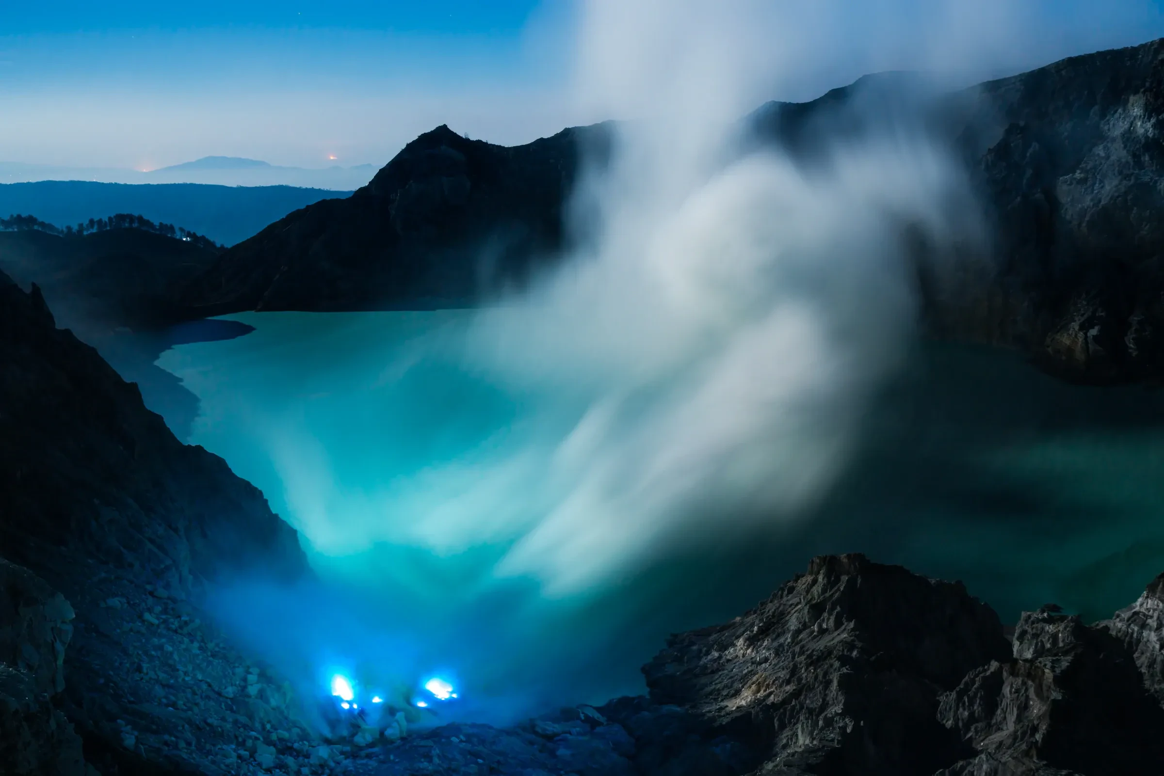 Blue flames glowing on the floor of Kawah Ijen crater before sunrise