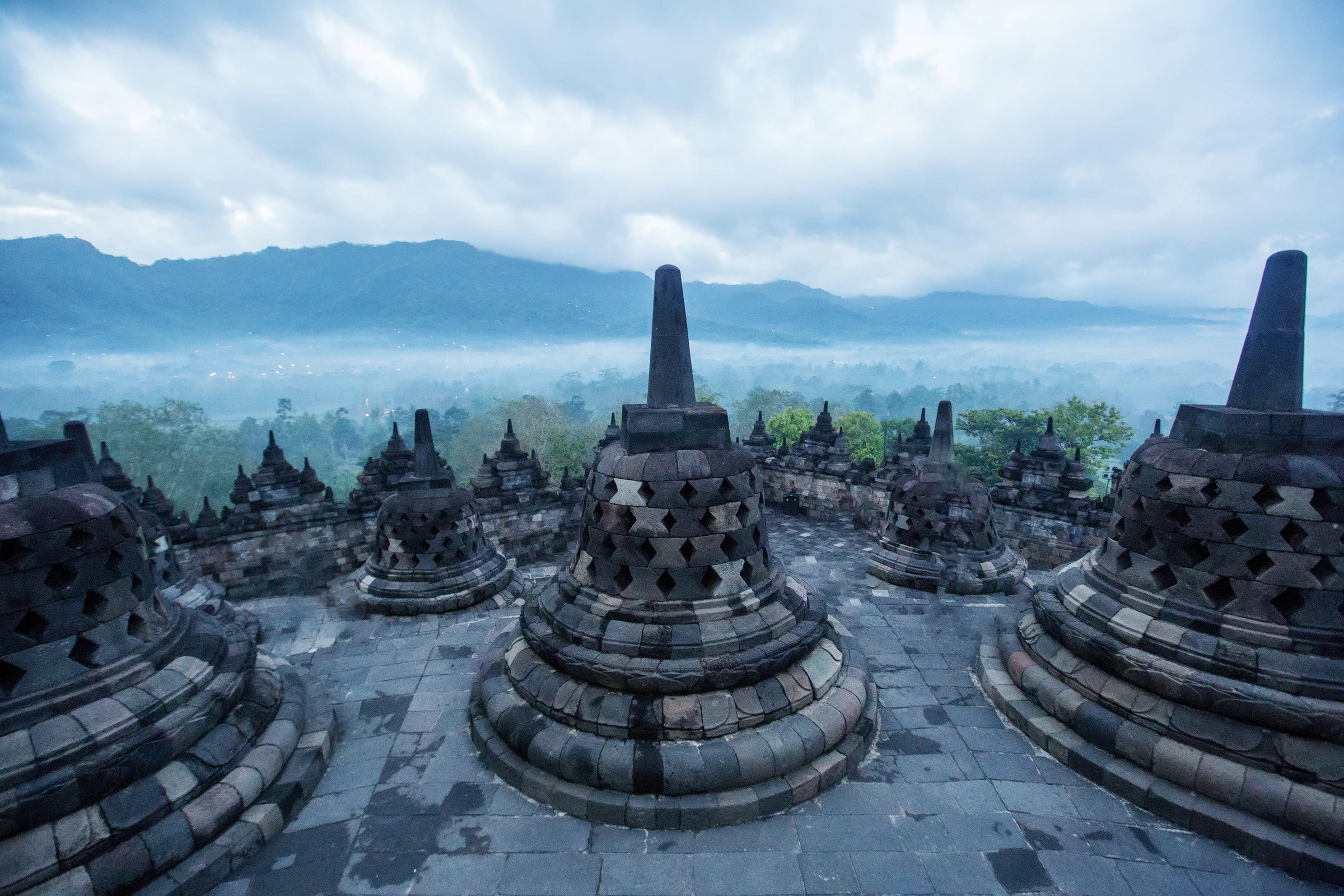 Borobudur's stupas on the upper terrace above a misty plain