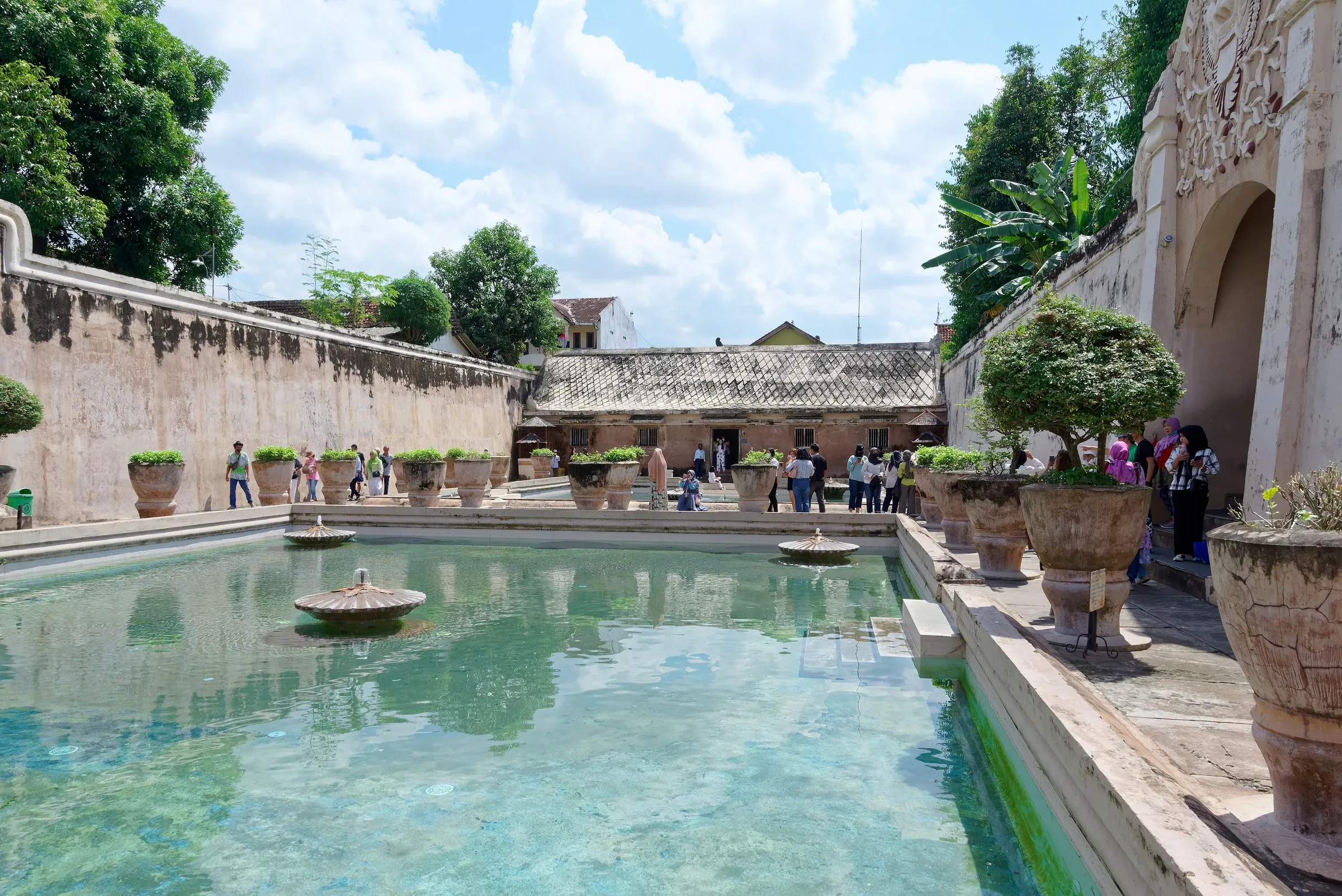 Turquoise bathing pool ringed by old stone walls at Taman Sari Water Castle, Yogyakarta