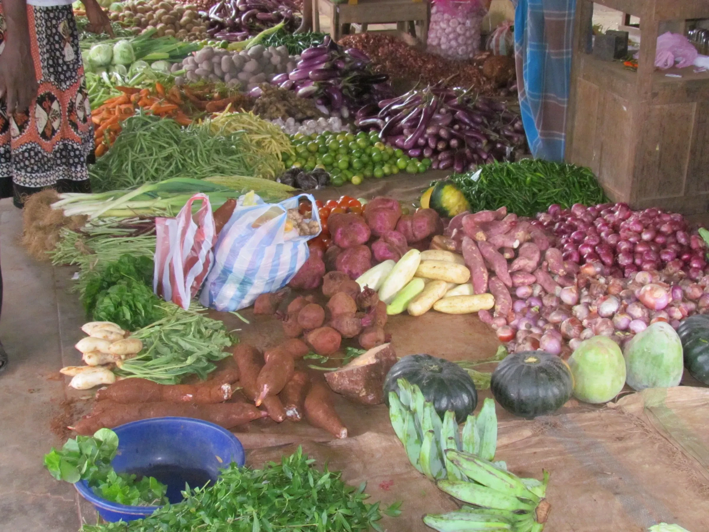 Piles of vegetables, root crops and green bananas on a market stall in Jaffna