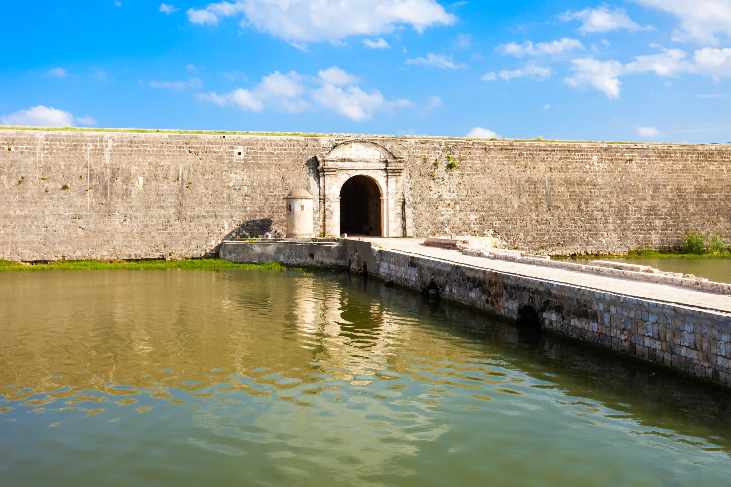 The stone ramparts and gateway of Jaffna Fort beside the water-filled moat