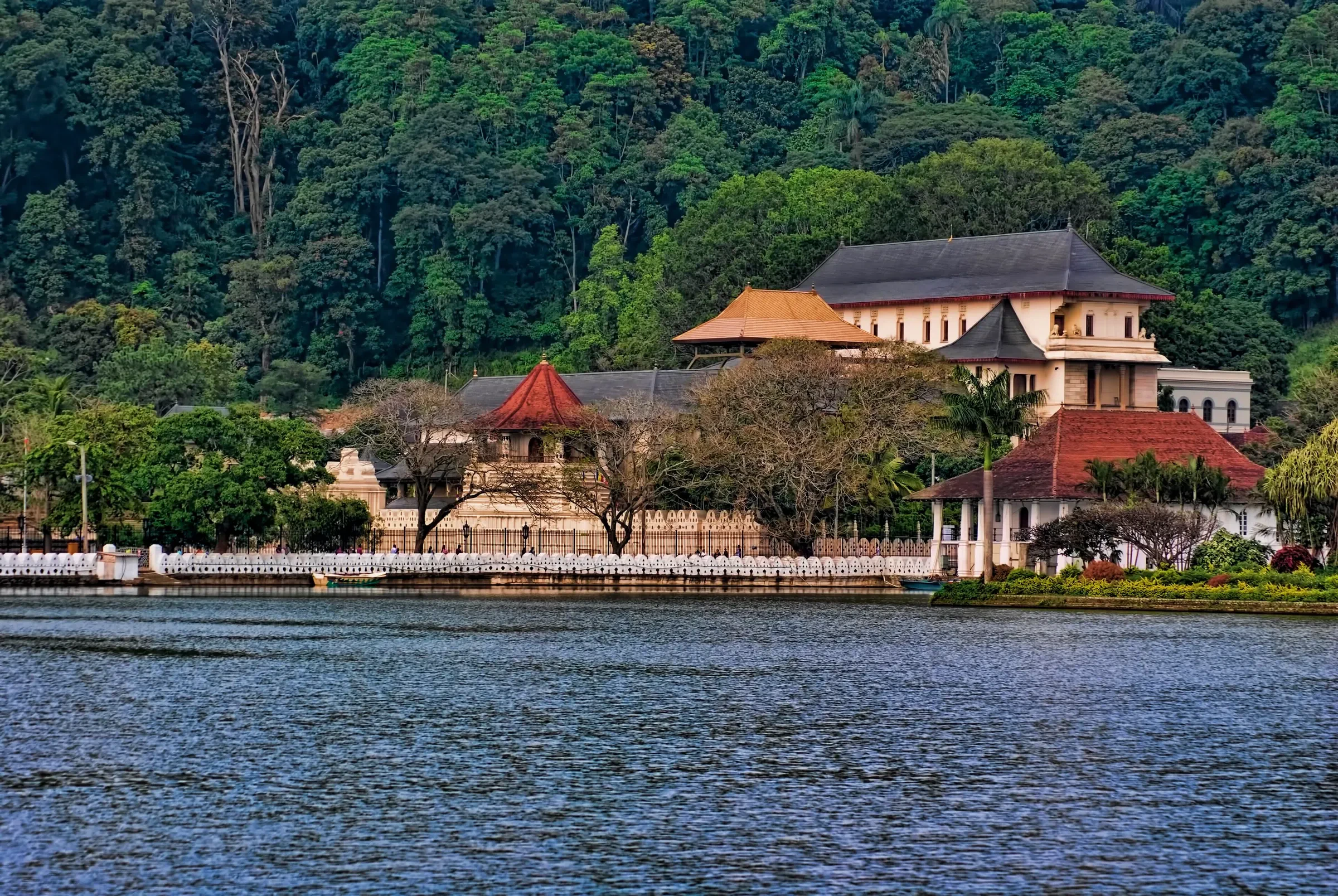 Kandy Lake with the Temple of the Sacred Tooth Relic on its far shore, below a wooded hill