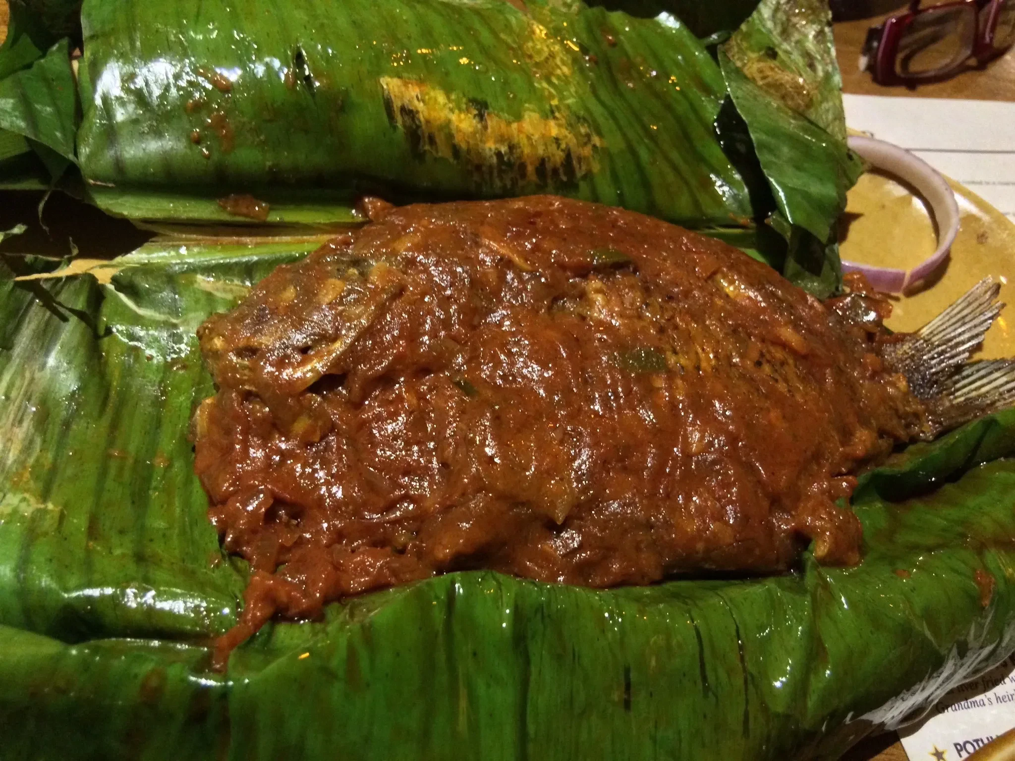 Karimeen pollichathu, pearl spot fish cooked in a banana leaf