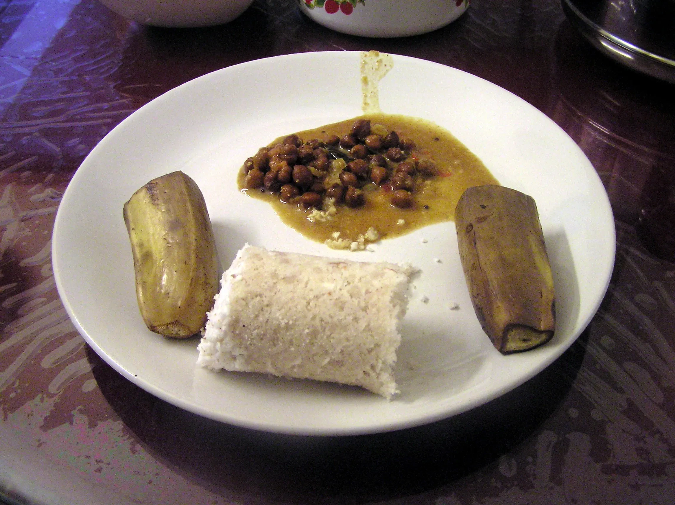 Puttu with kadala curry and a steamed banana on a plate