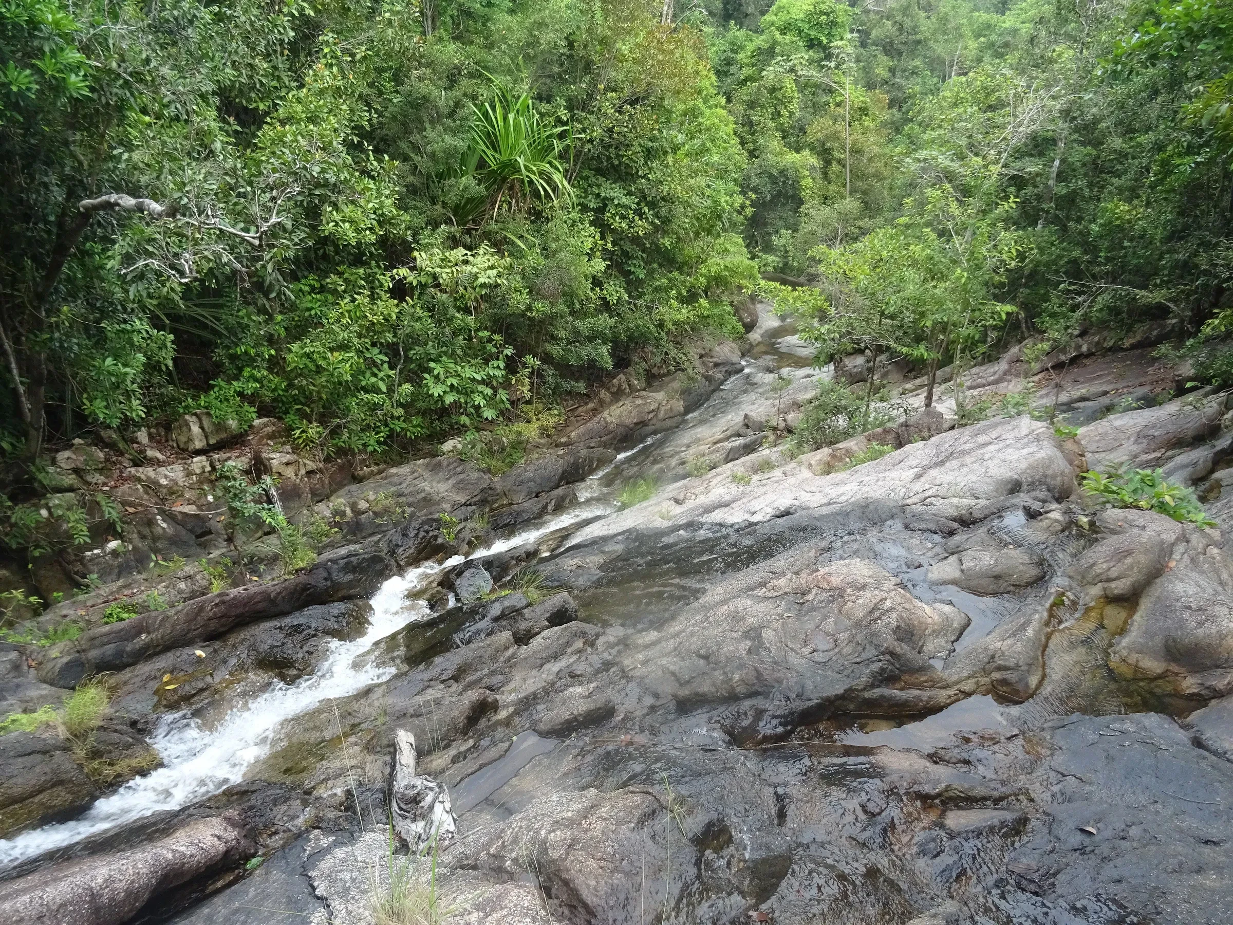 Water running down the granite slabs of Phaeng Waterfall in the forest on Koh Phangan