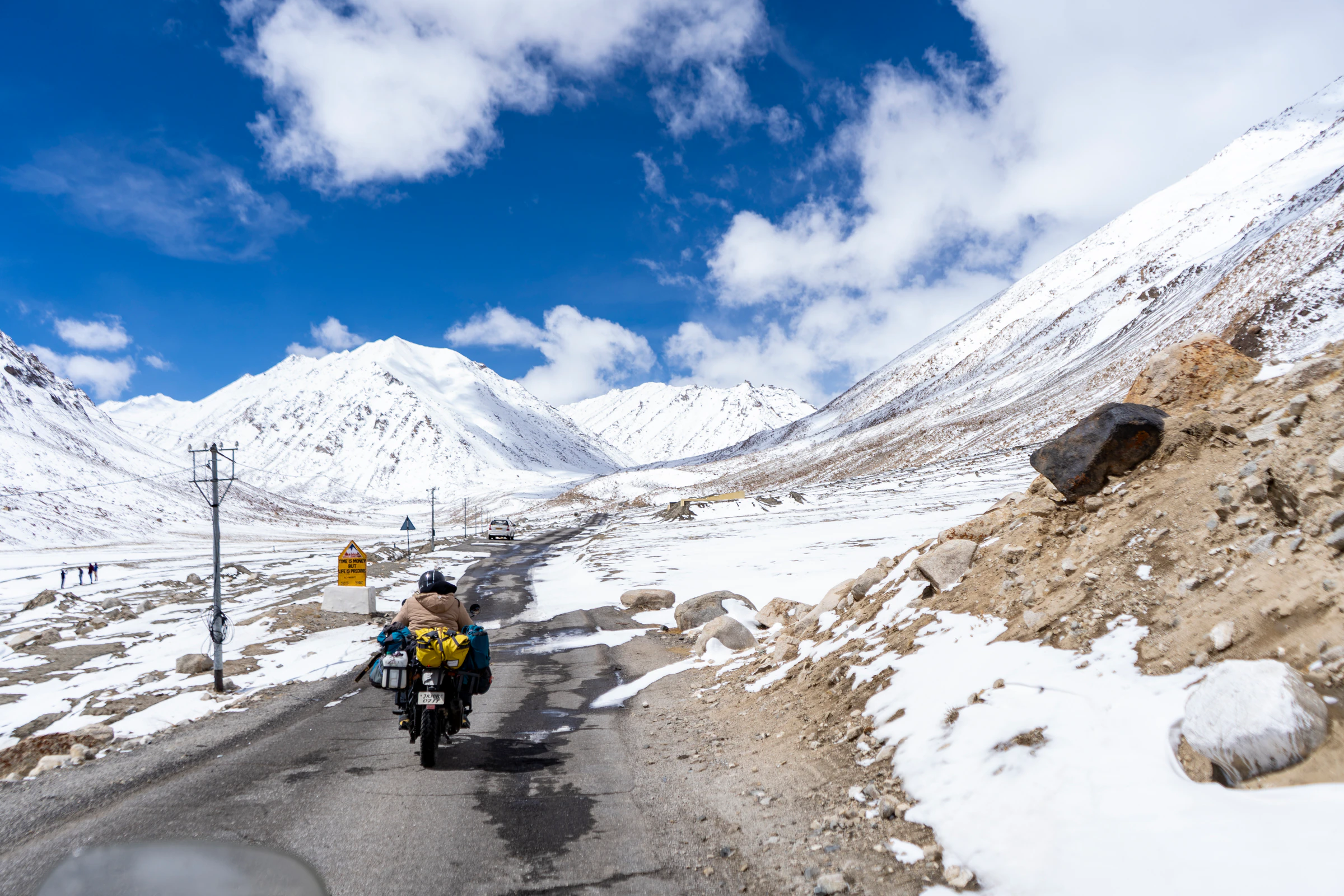 A helmeted rider on a snowy road near Khardung La, Ladakh