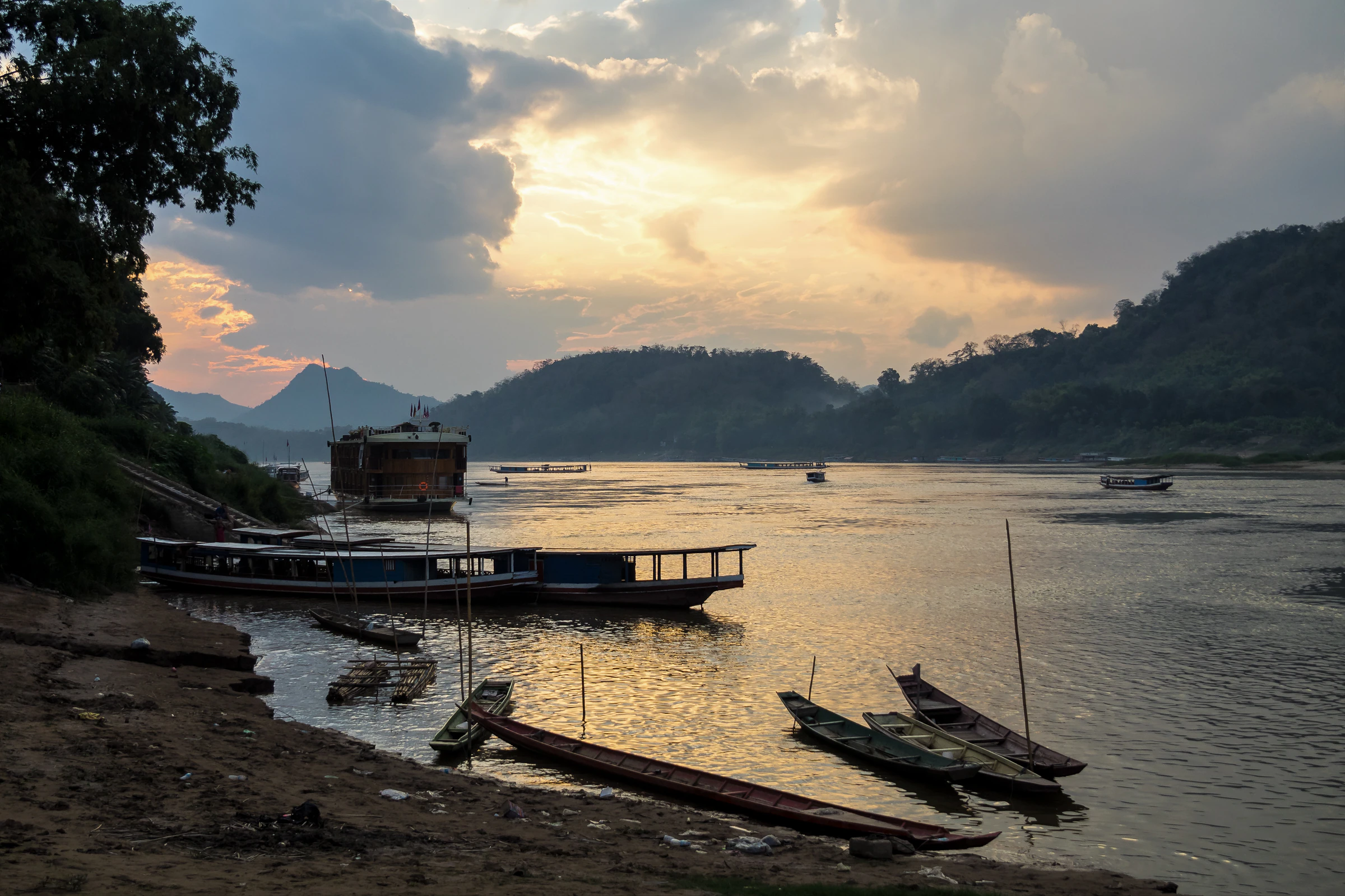 Wooden longboats moored on the Mekong near Luang Prabang at dusk