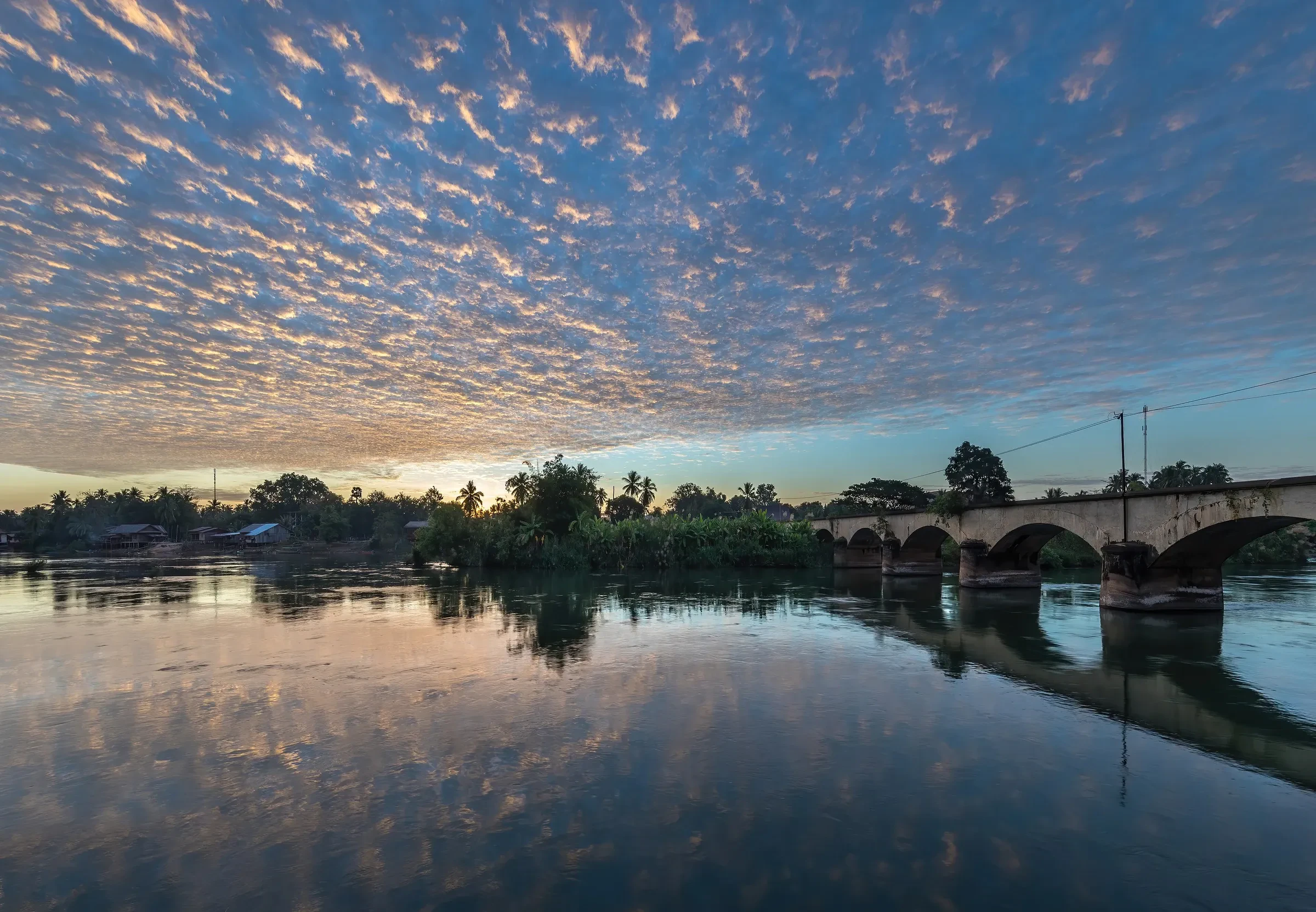 The old stone railway bridge to Don Khon seen from Don Det at sunrise