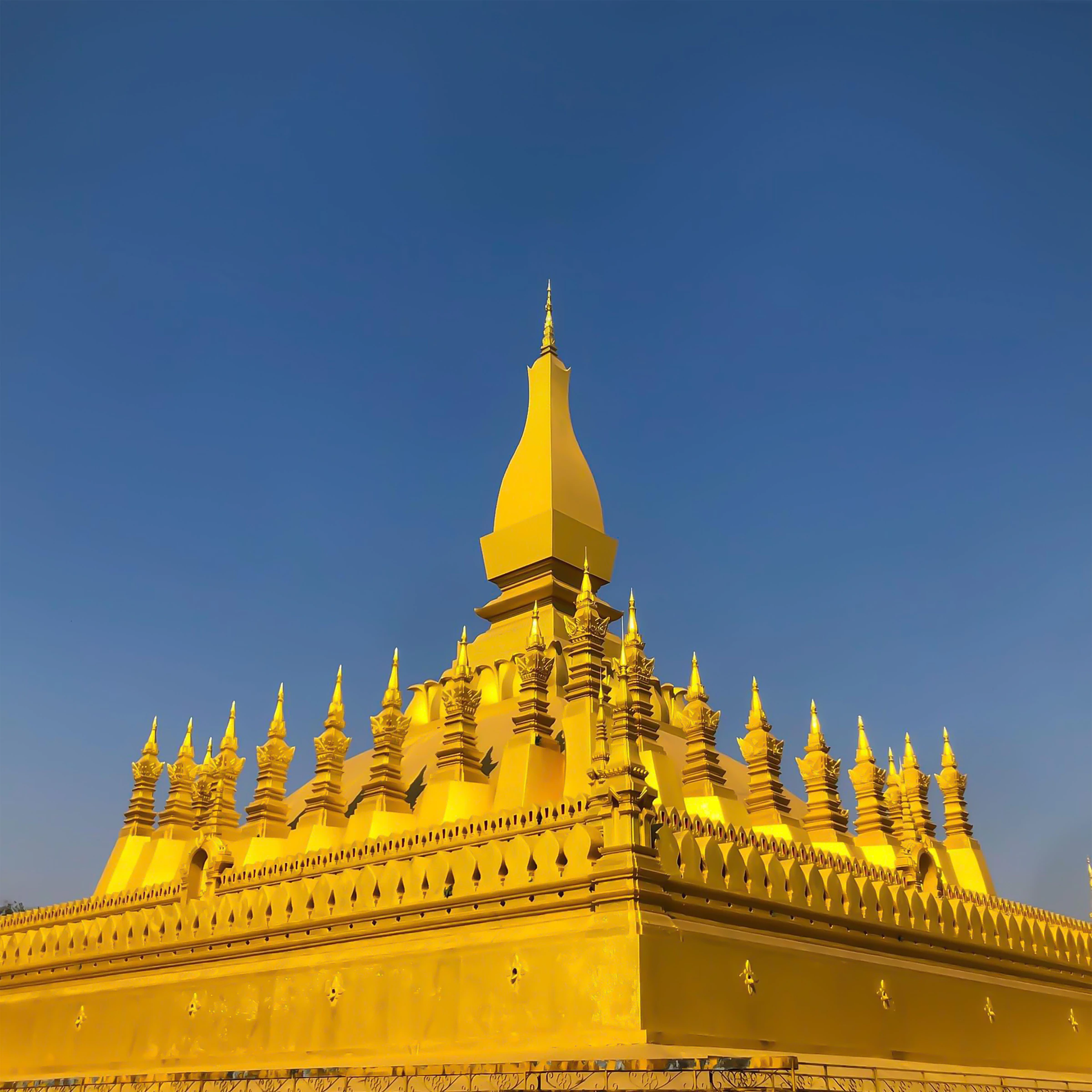 The golden stupa of Pha That Luang in Vientiane against a blue sky