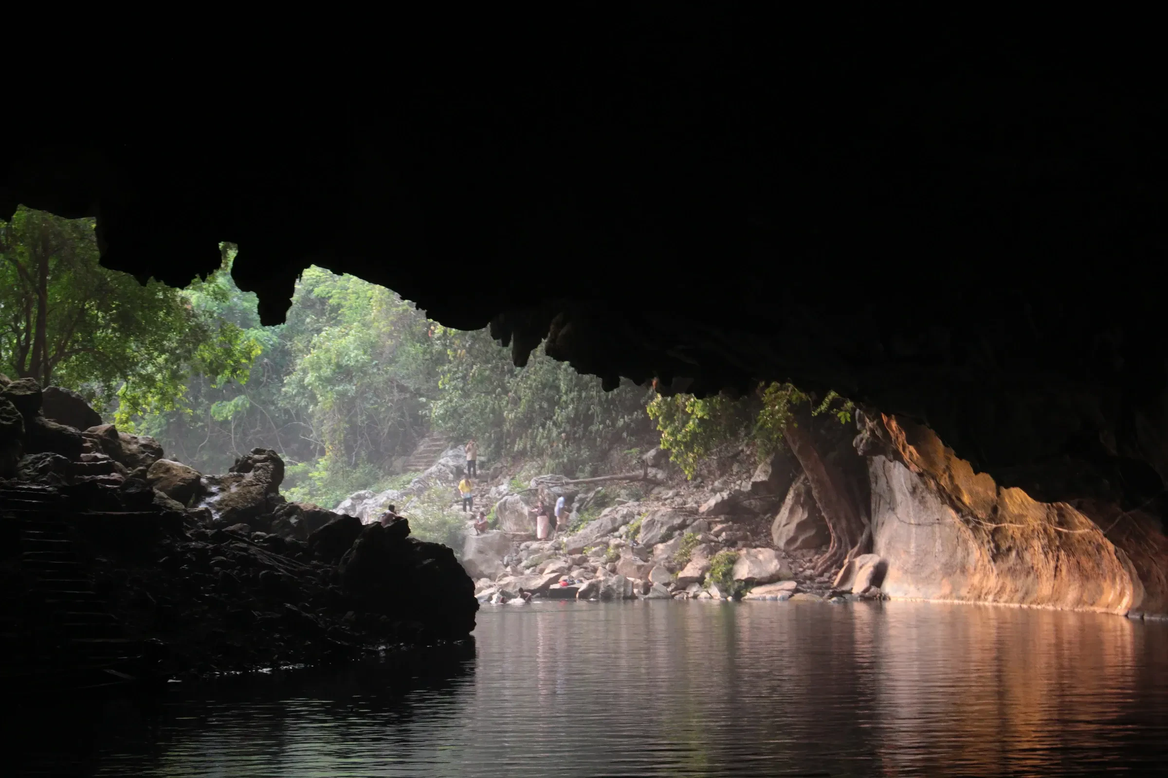 Long boats on the river at the mouth of Kong Lor Cave in Khammouane, Laos