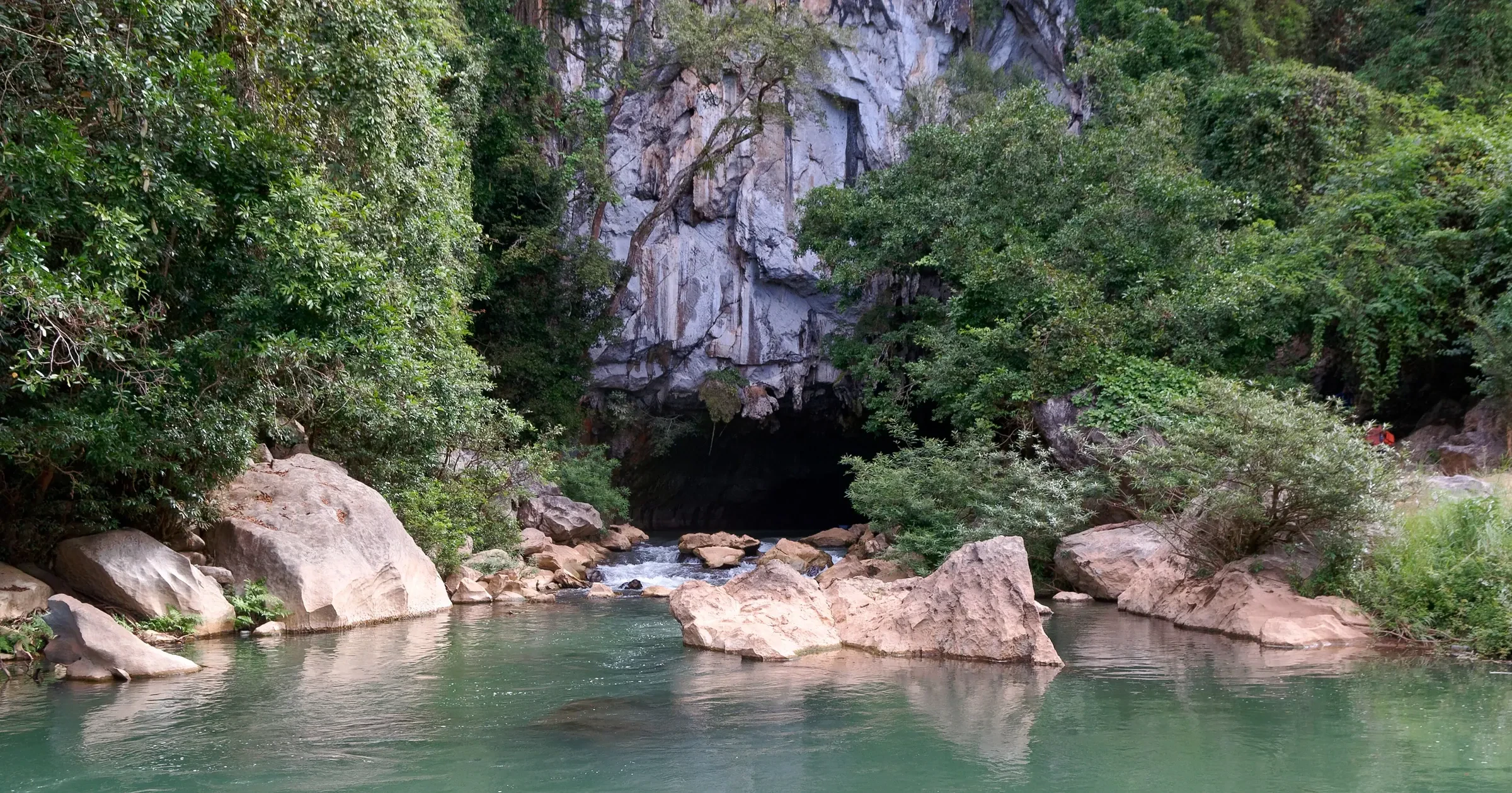 The jungle-covered limestone entrance to the Kong Lor cave in central Laos