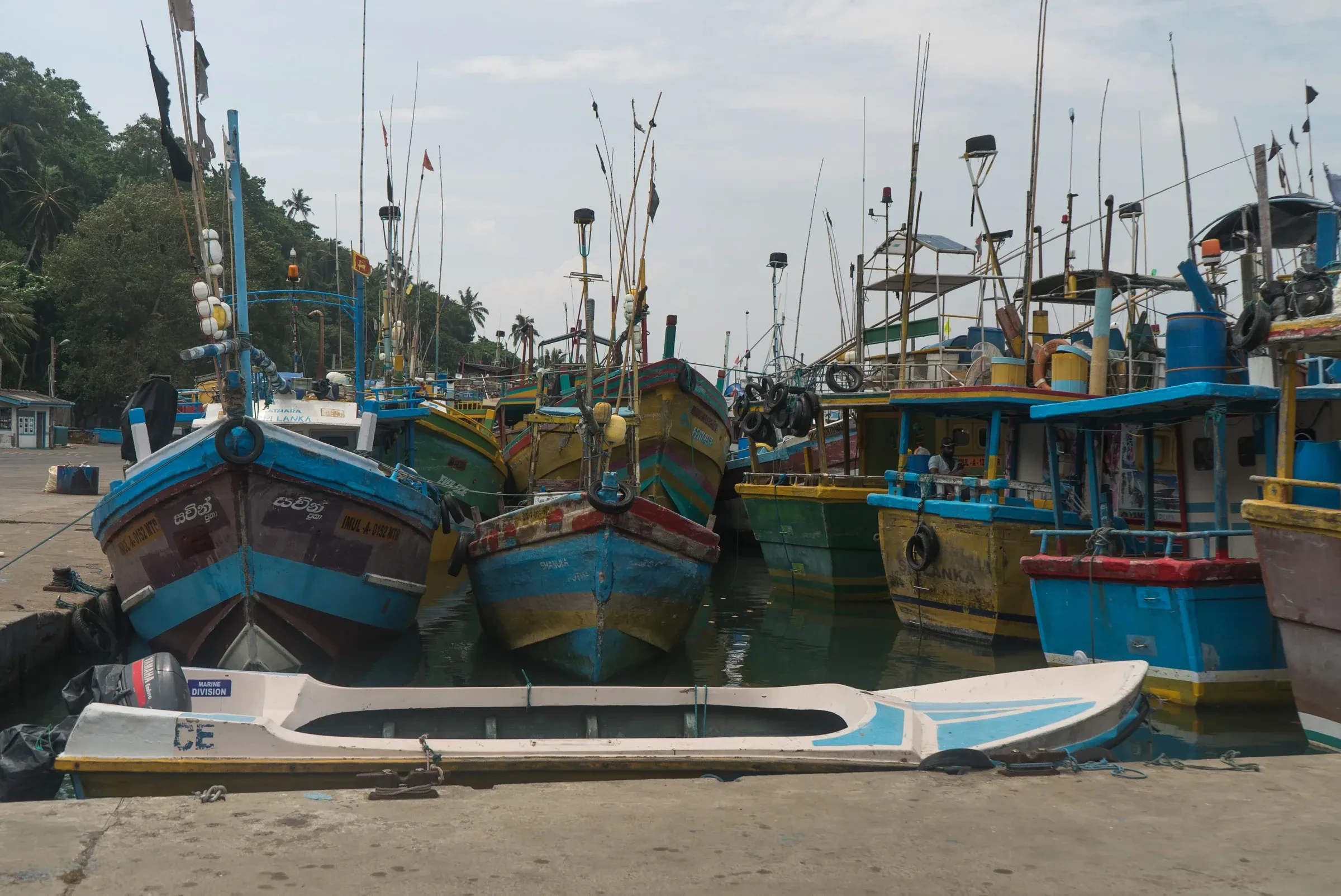 Brightly painted fishing boats packed together in Mirissa harbour