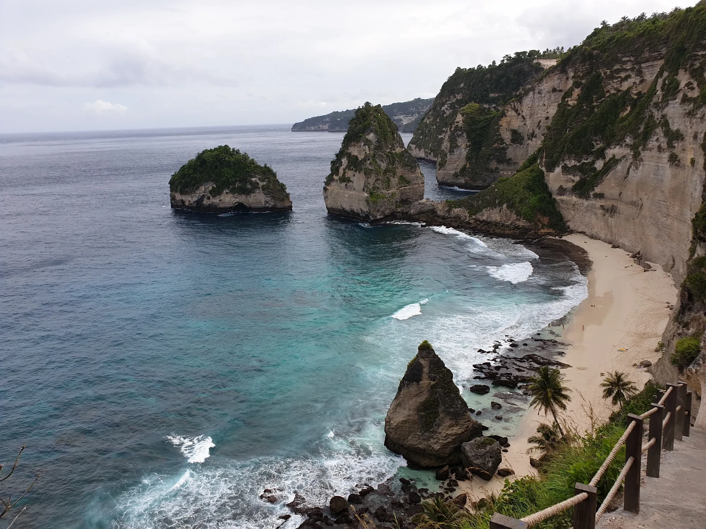 Diamond Beach on Nusa Penida's east coast, with sea stacks off the cliffs and a stairway down to the sand