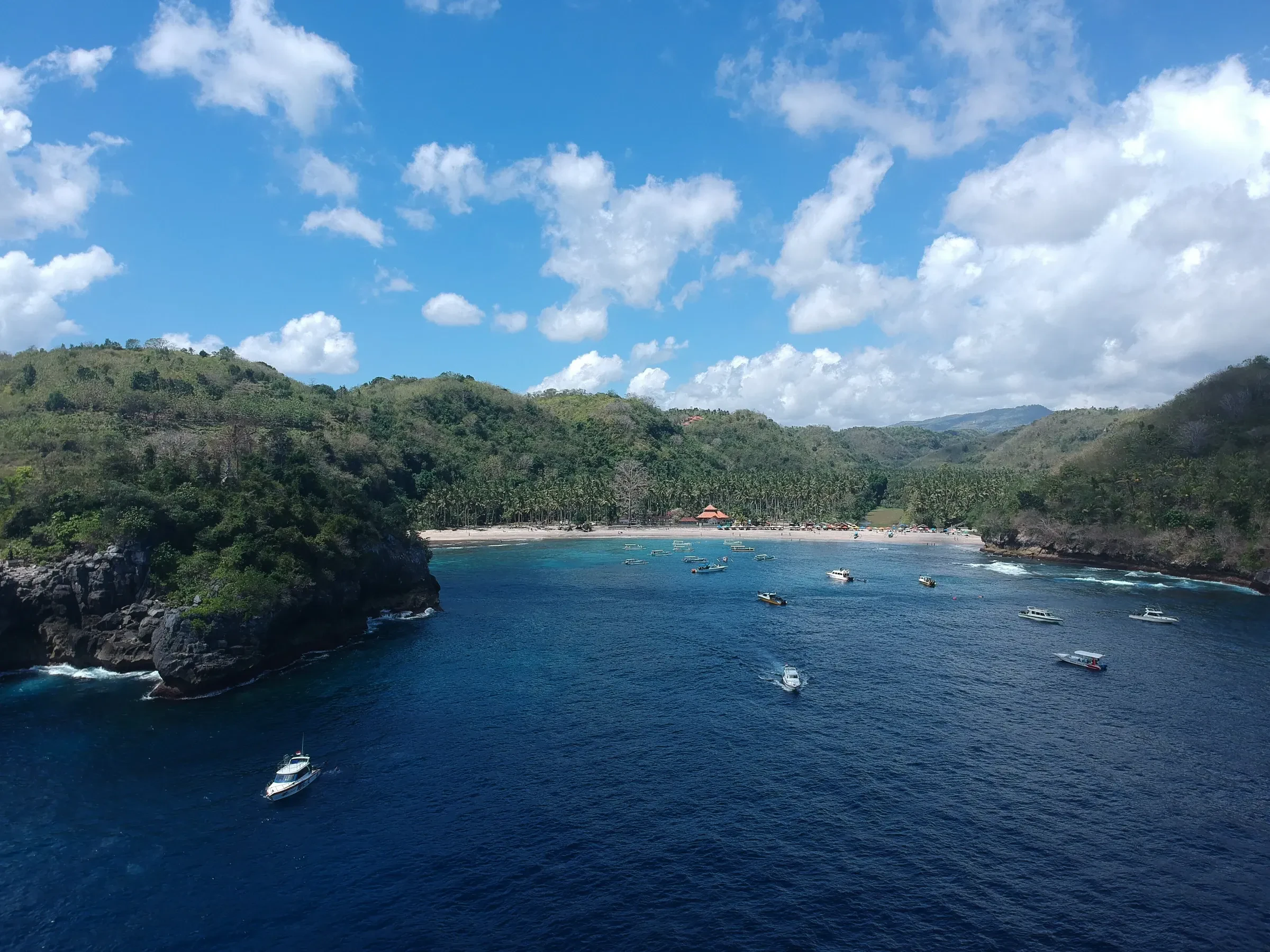 Boats moored in Crystal Bay on the west coast of Nusa Penida, with the beach behind