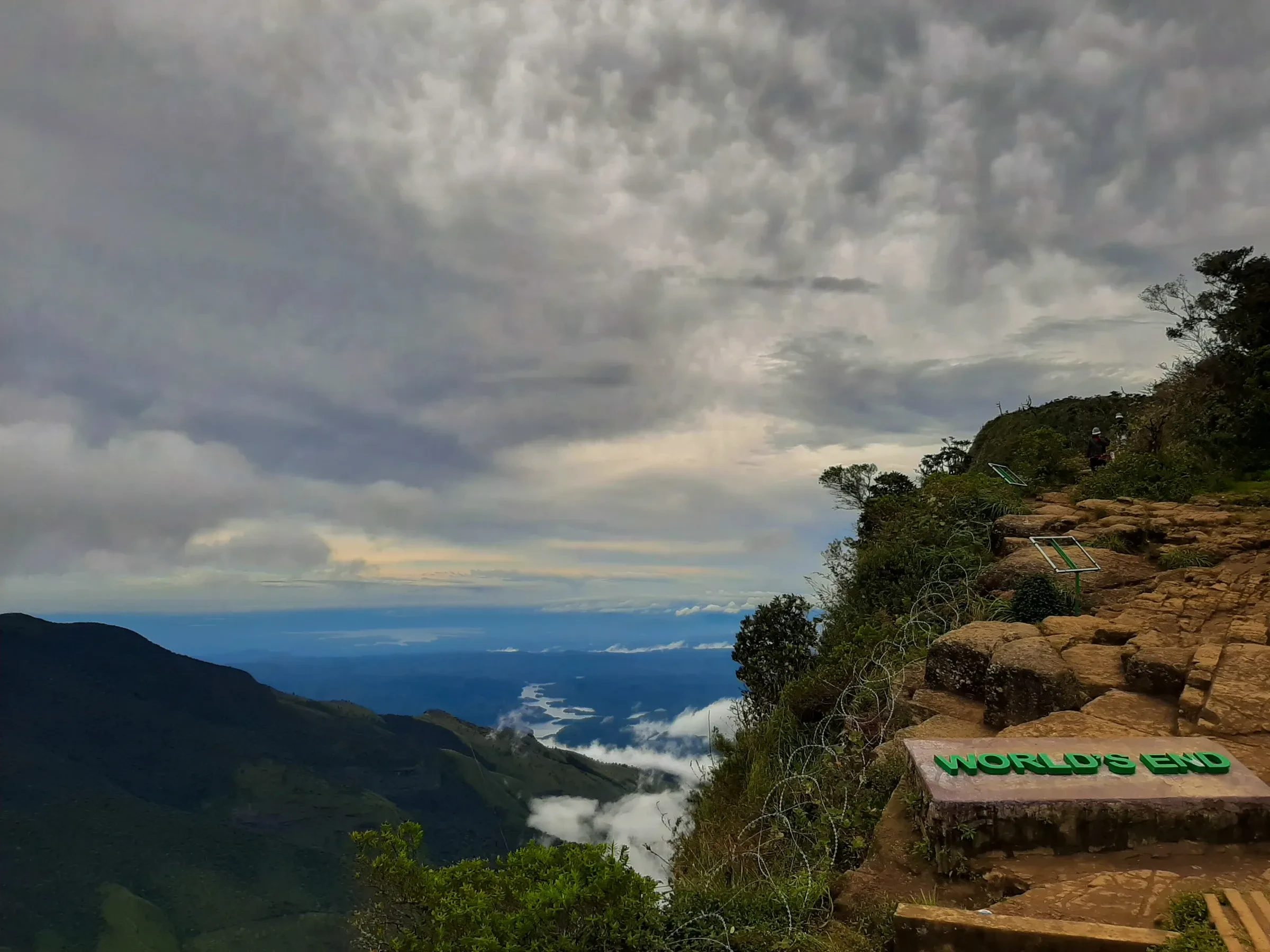 The World's End sign on a rocky ledge at Horton Plains, with cloud in the valley below