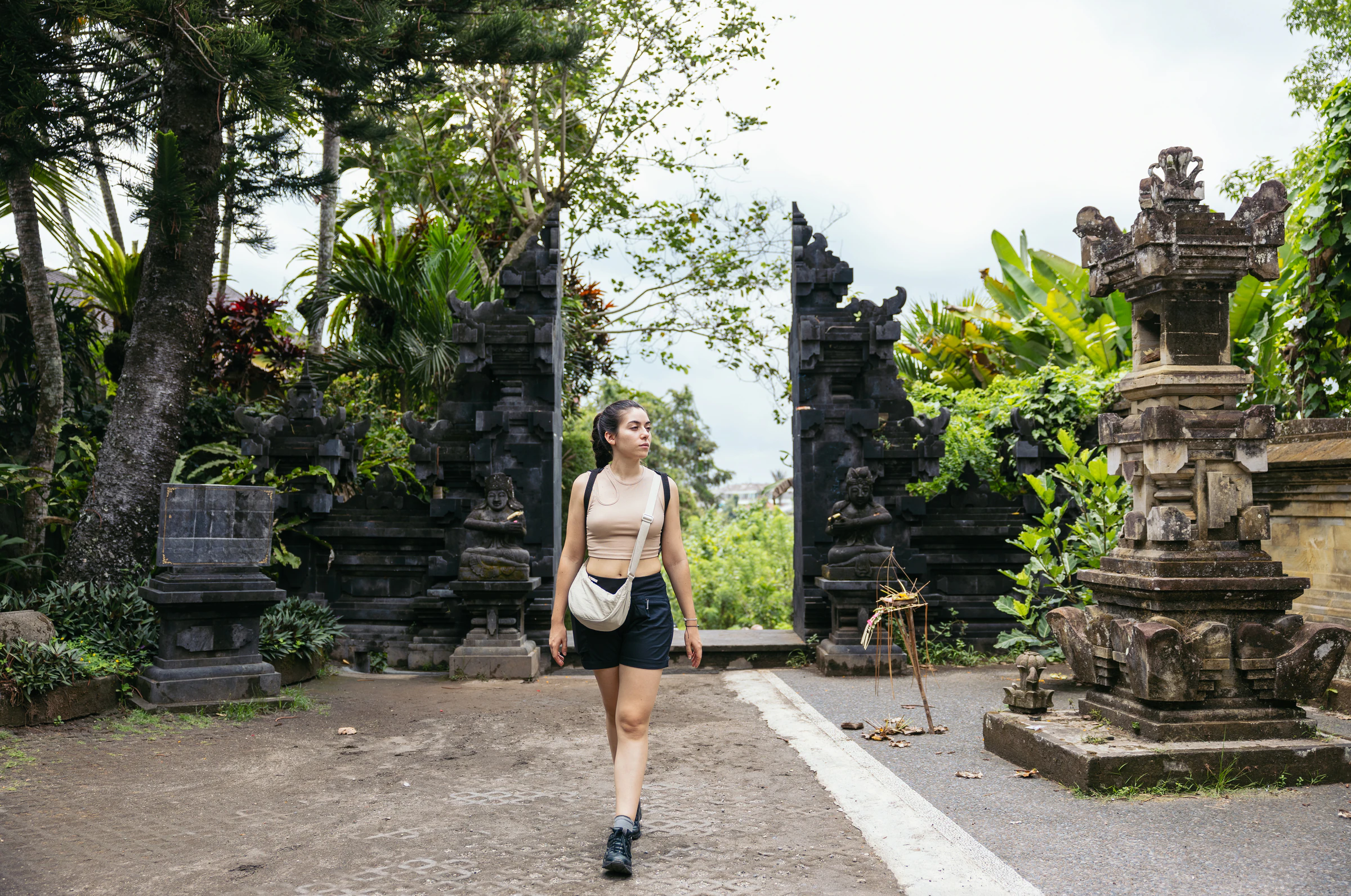 A woman walks through an ornate Balinese temple gateway