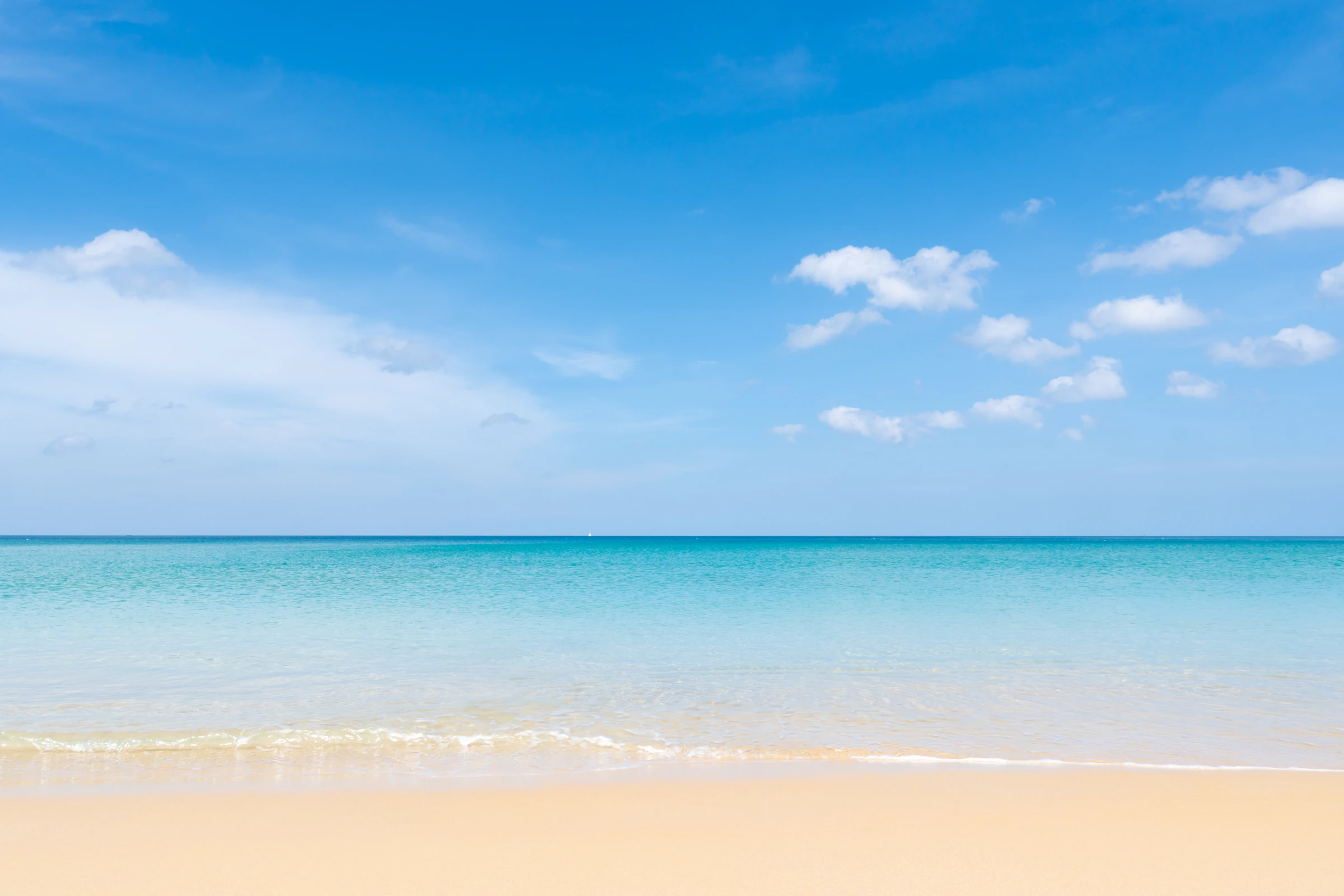 Calm turquoise water off a Phuket beach under a clear sky