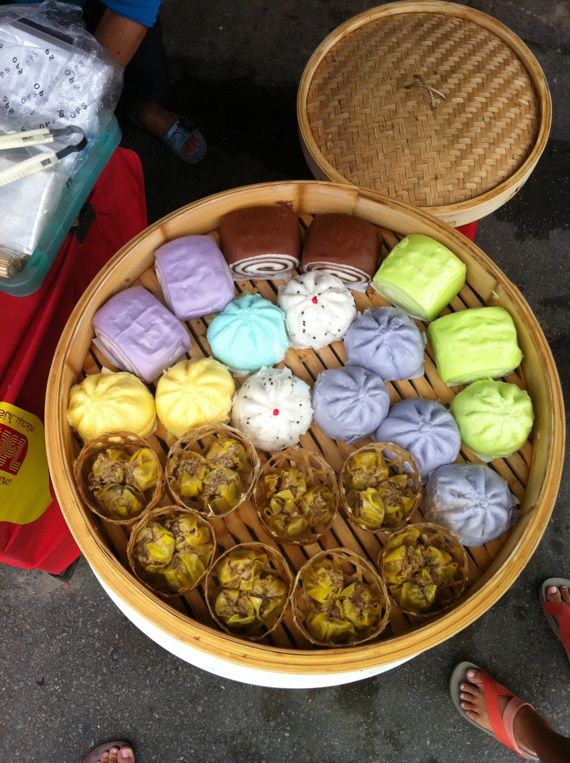 A bamboo steamer of colourful steamed buns and dumplings at a food stall during the Phuket Vegetarian Festival