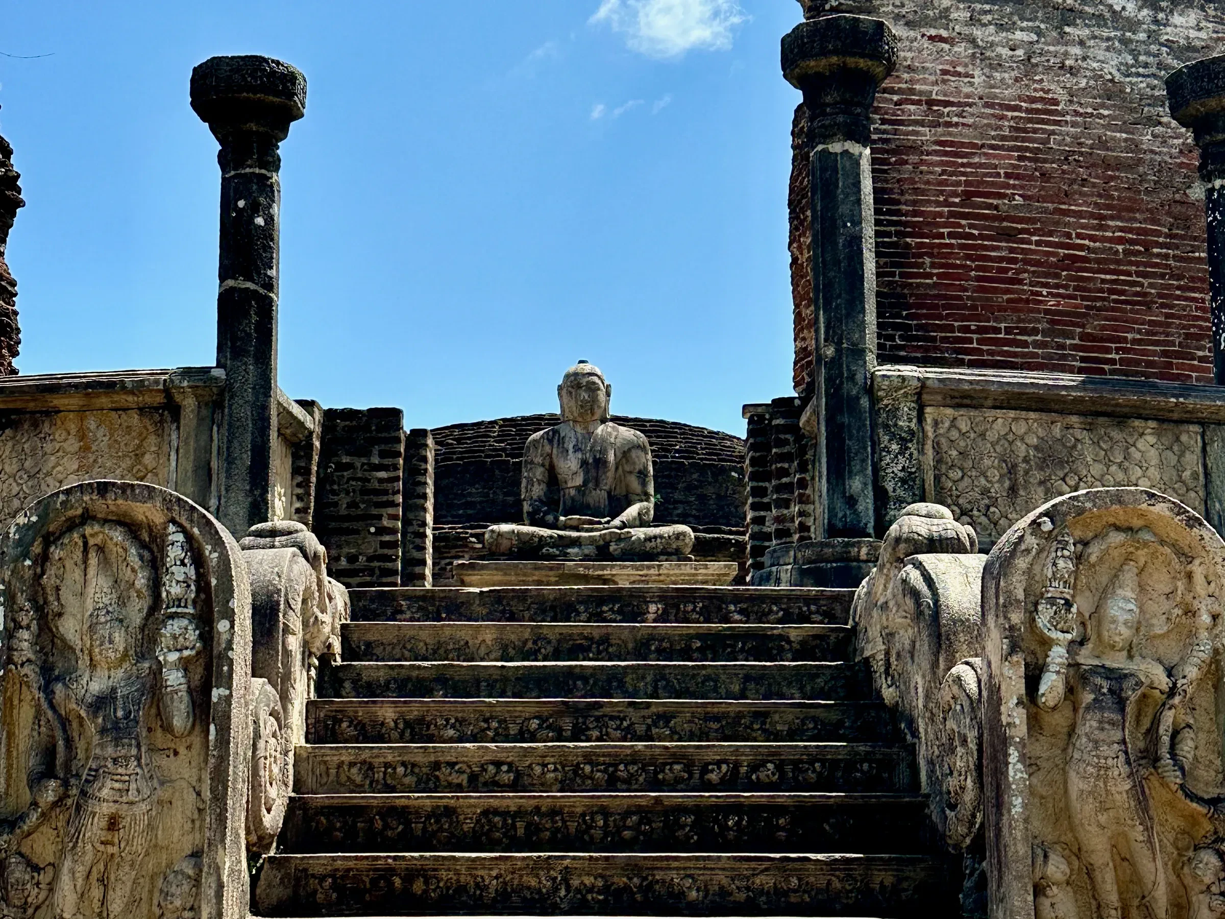 Steps and a seated Buddha inside the circular Vatadage in Polonnaruwa's Quadrangle