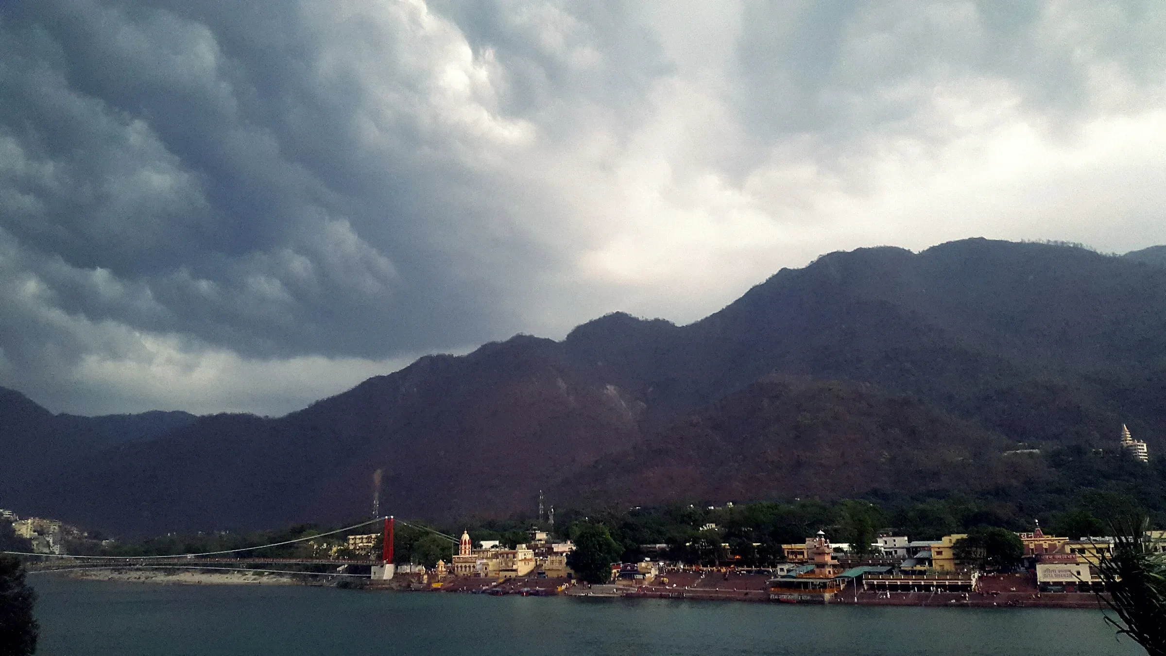 Dark monsoon clouds over the hills above Rishikesh and the Ganga