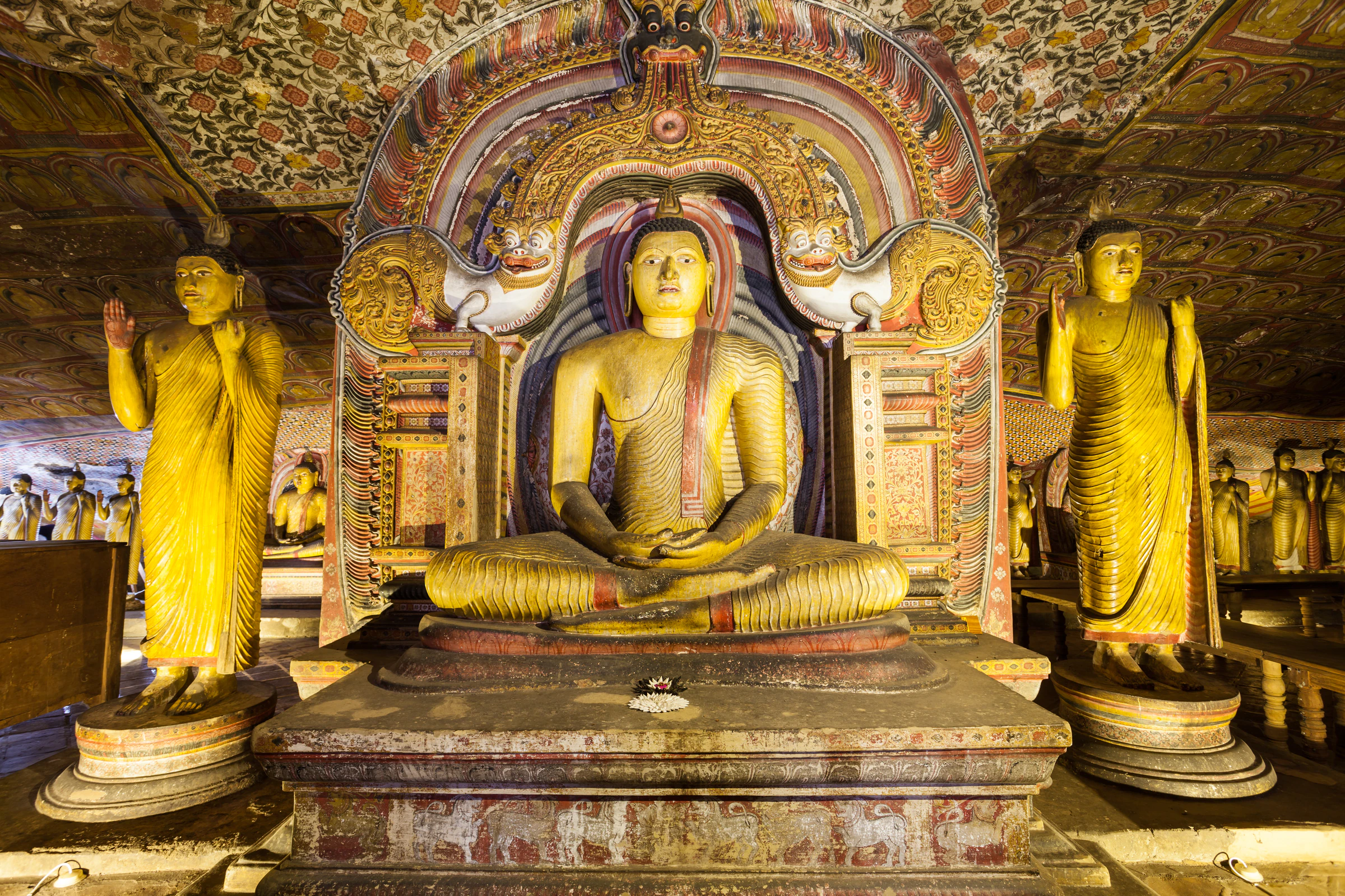 Seated and standing Buddha statues inside one of the Dambulla cave temples