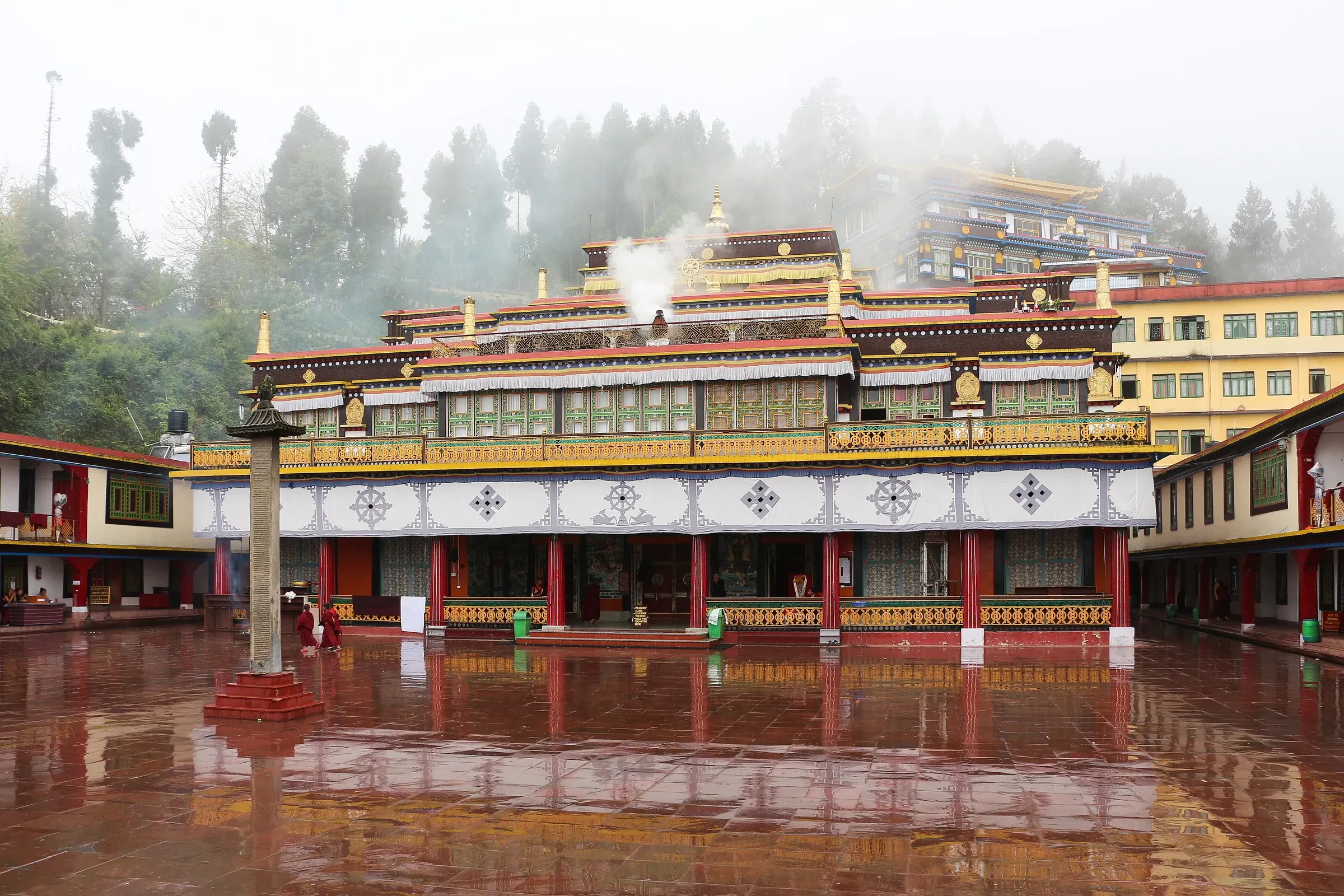 Rumtek Monastery's prayer hall and wet courtyard in the mist near Gangtok