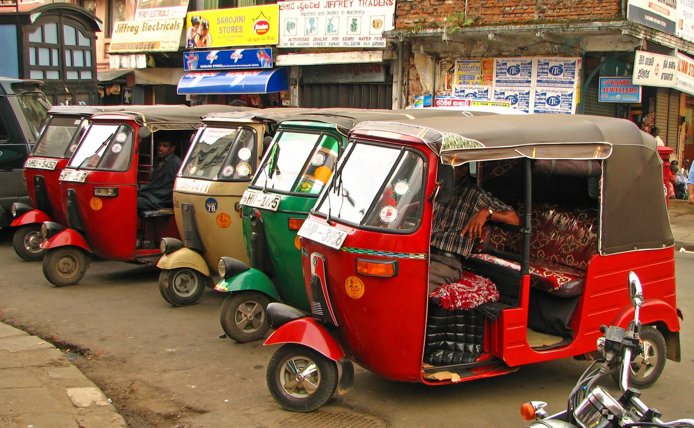Colourful tuk-tuks waiting in a row in Kandy