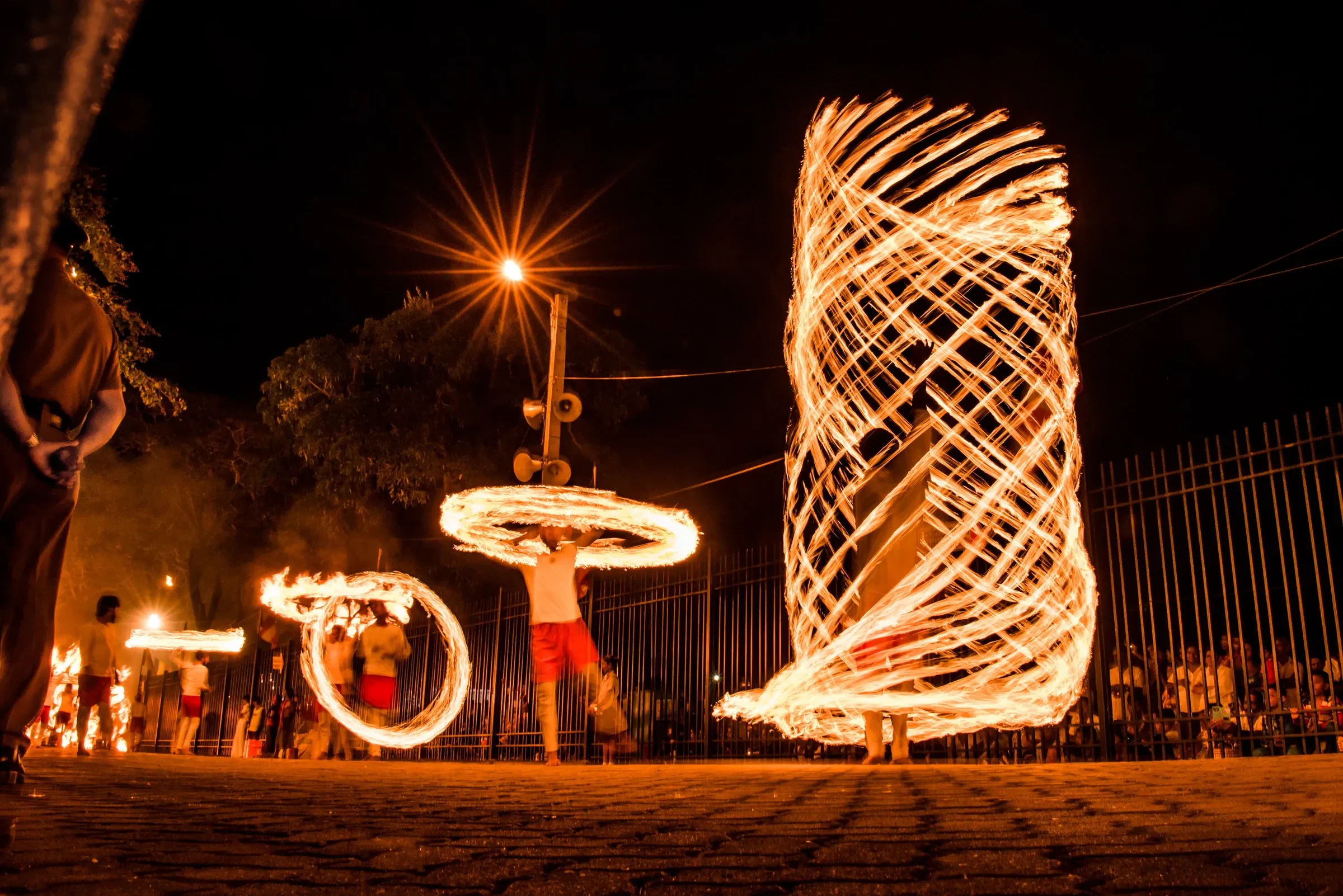 A performer spinning fire on a Kandy street during the Esala Perahera at night