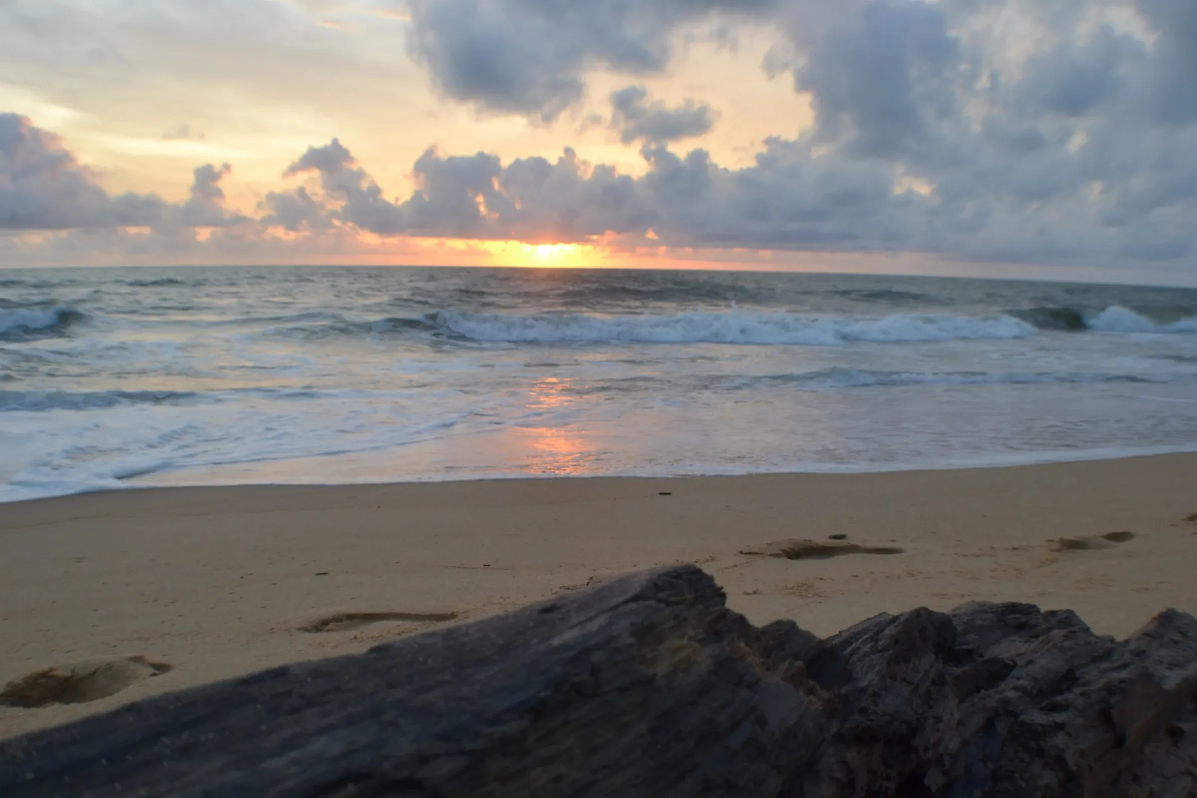 Waves and a rocky shore on Negombo beach at sunset