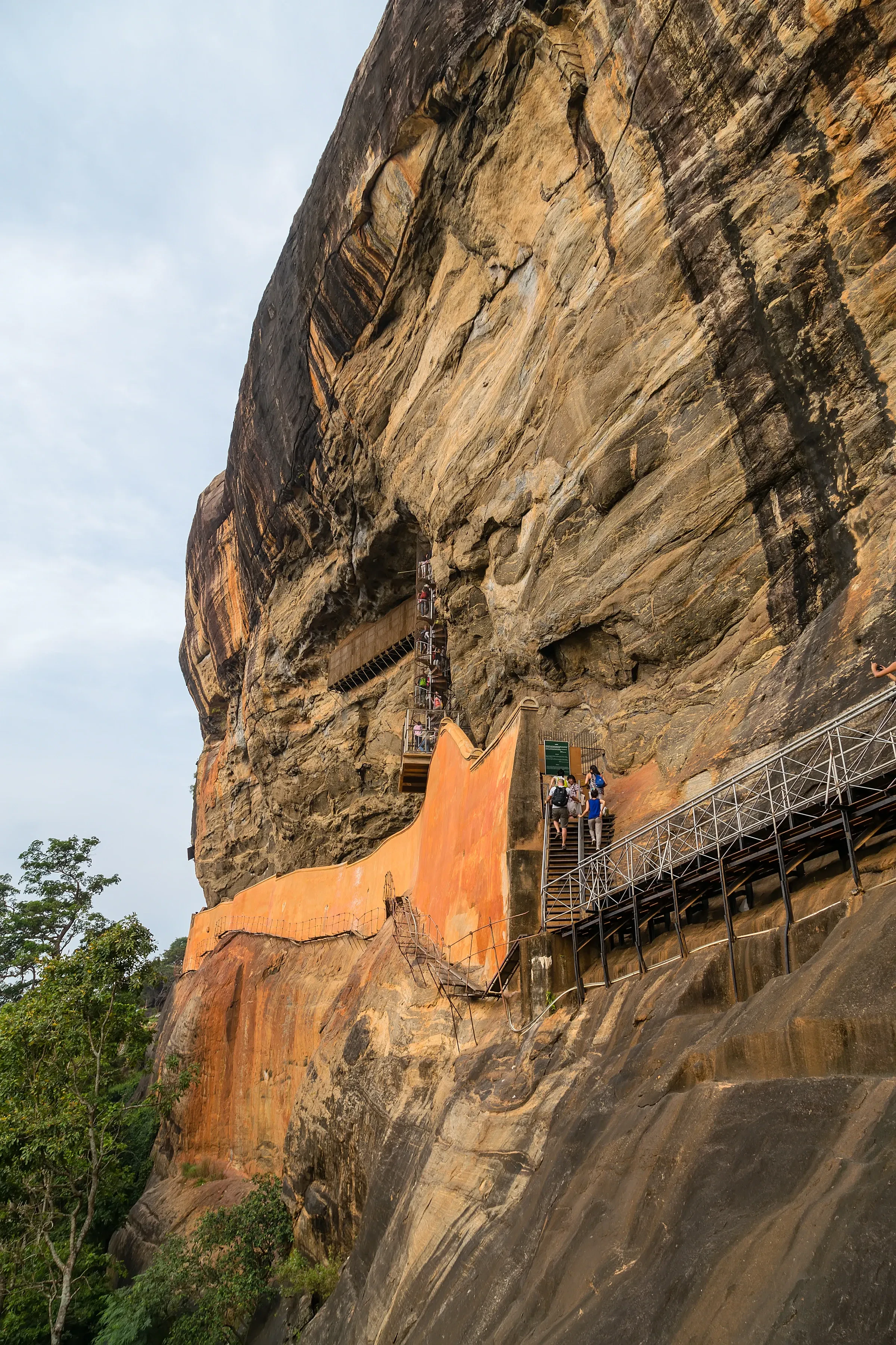 Travellers climbing the stairway toward the summit of Sigiriya Rock in Sri Lanka