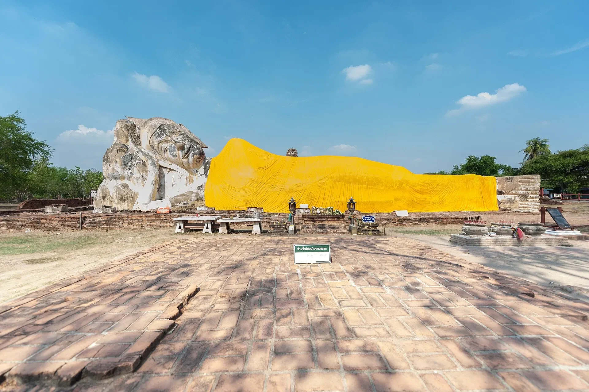 The open-air reclining Buddha at Wat Lokayasutharam, wrapped in an orange robe, in Ayutthaya