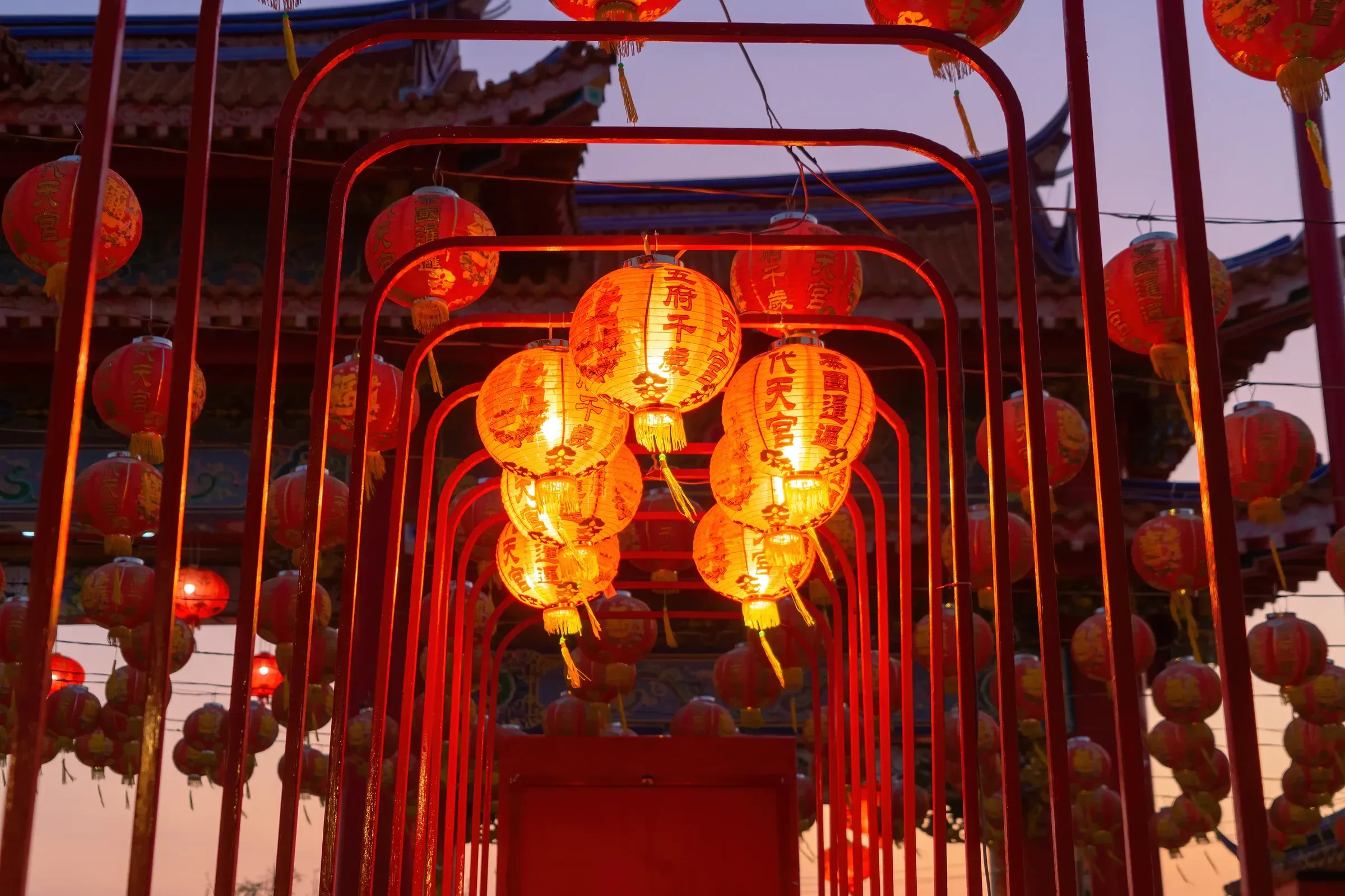 Rows of glowing red lanterns over the gateways of a Chinese temple at Chinese New Year