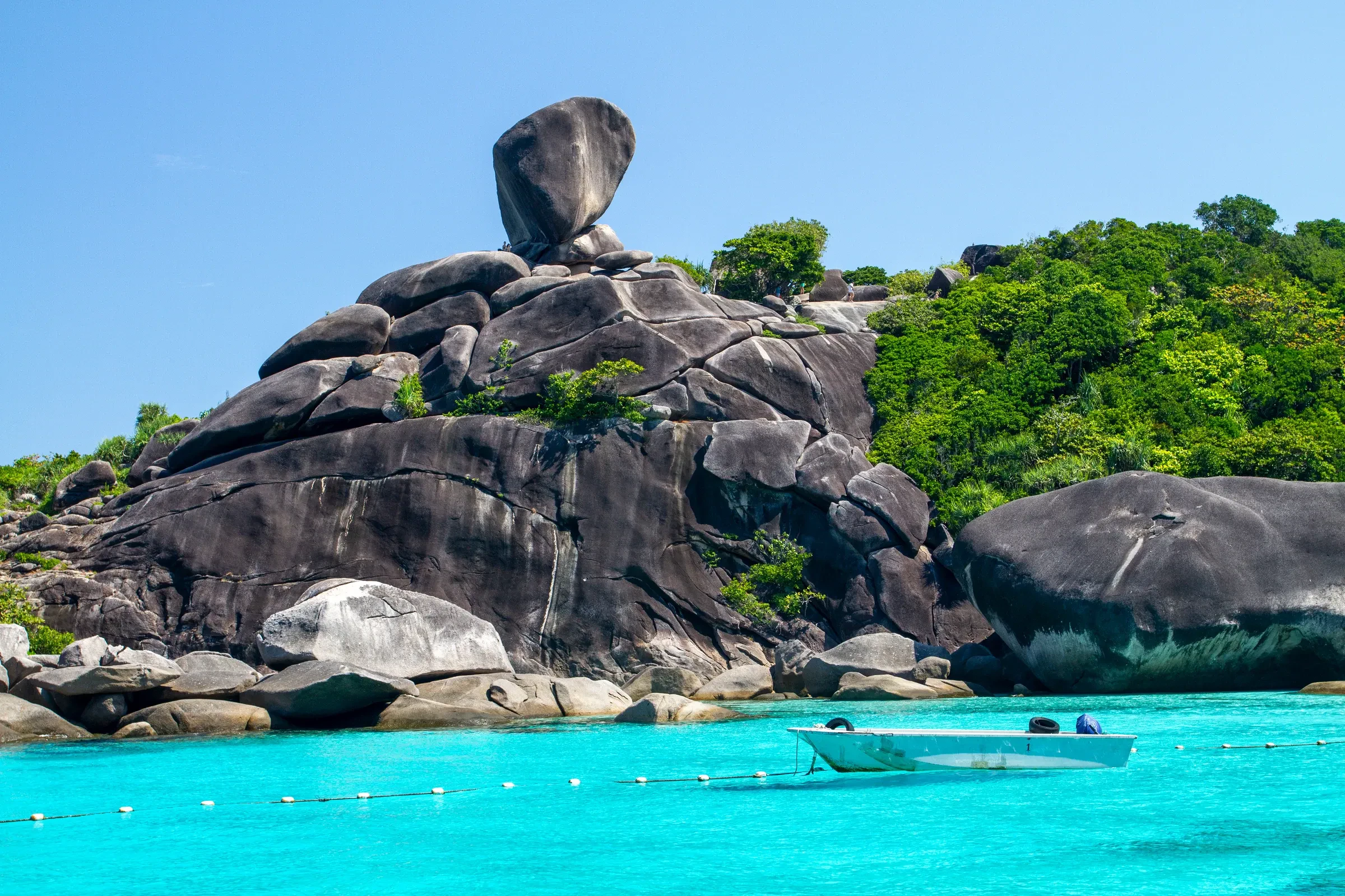 Granite boulders breaking the surface at the Similan Islands, with clear blue water around them