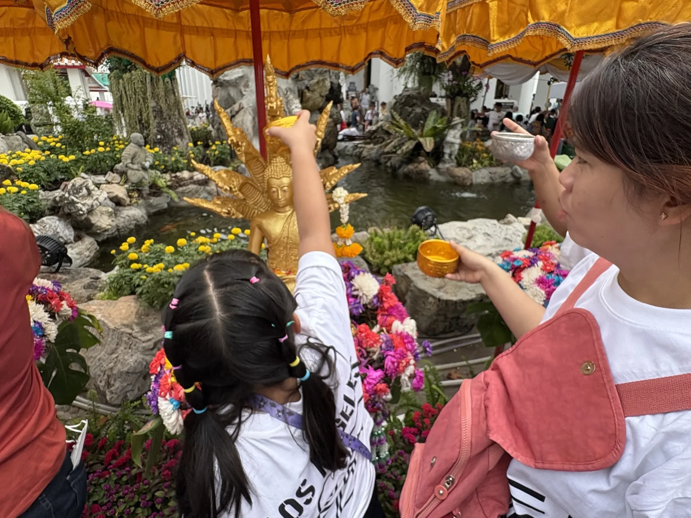 Pouring scented water over a Buddha image during Songkran
