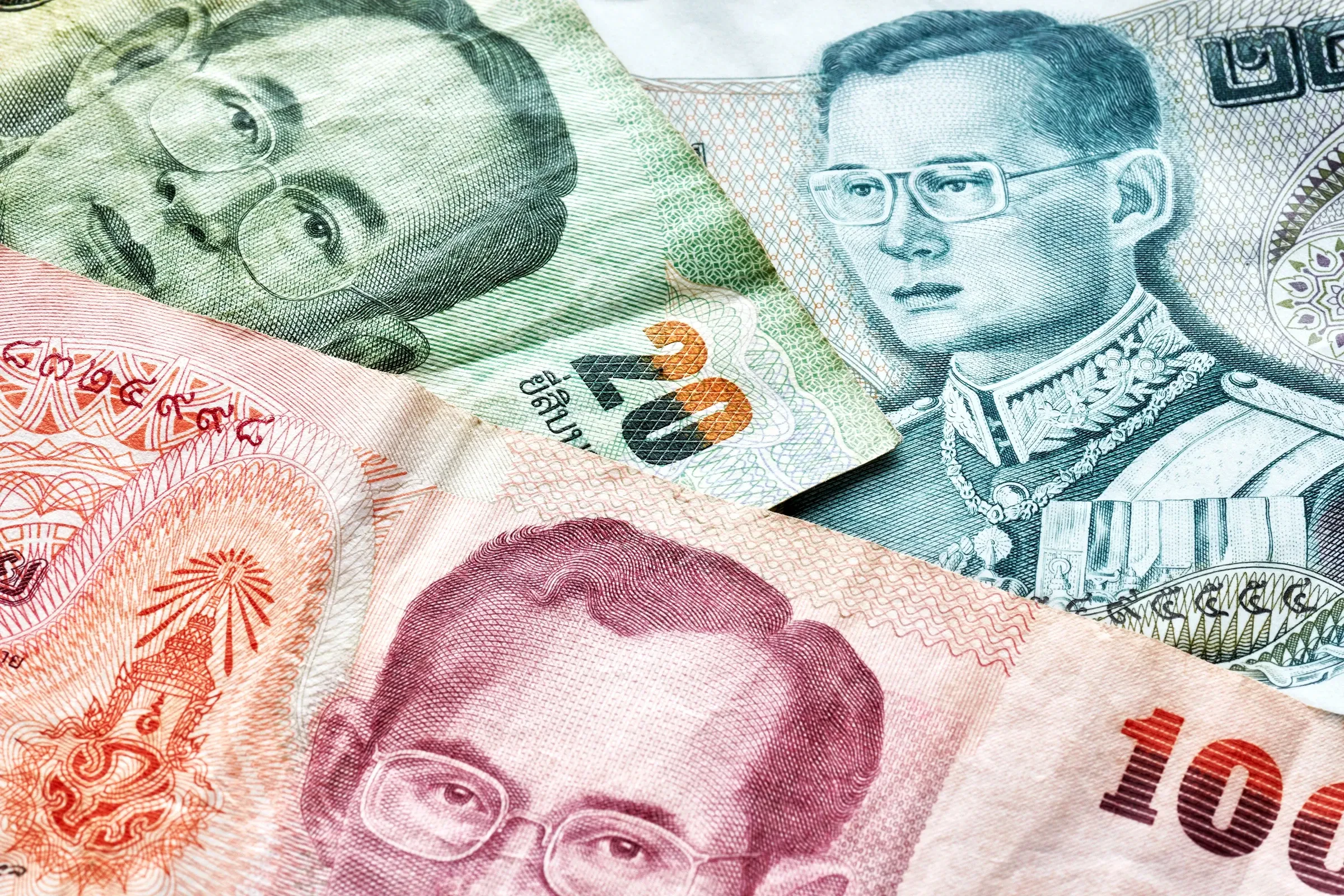 Thai baht banknotes of different values in a pile
