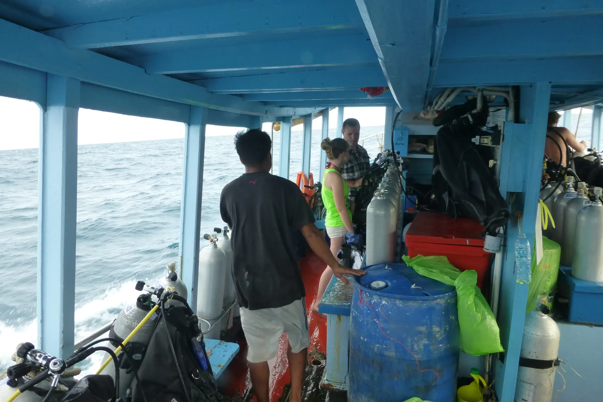 A dive boat deck at Koh Tao with tanks and gear stacked along the side