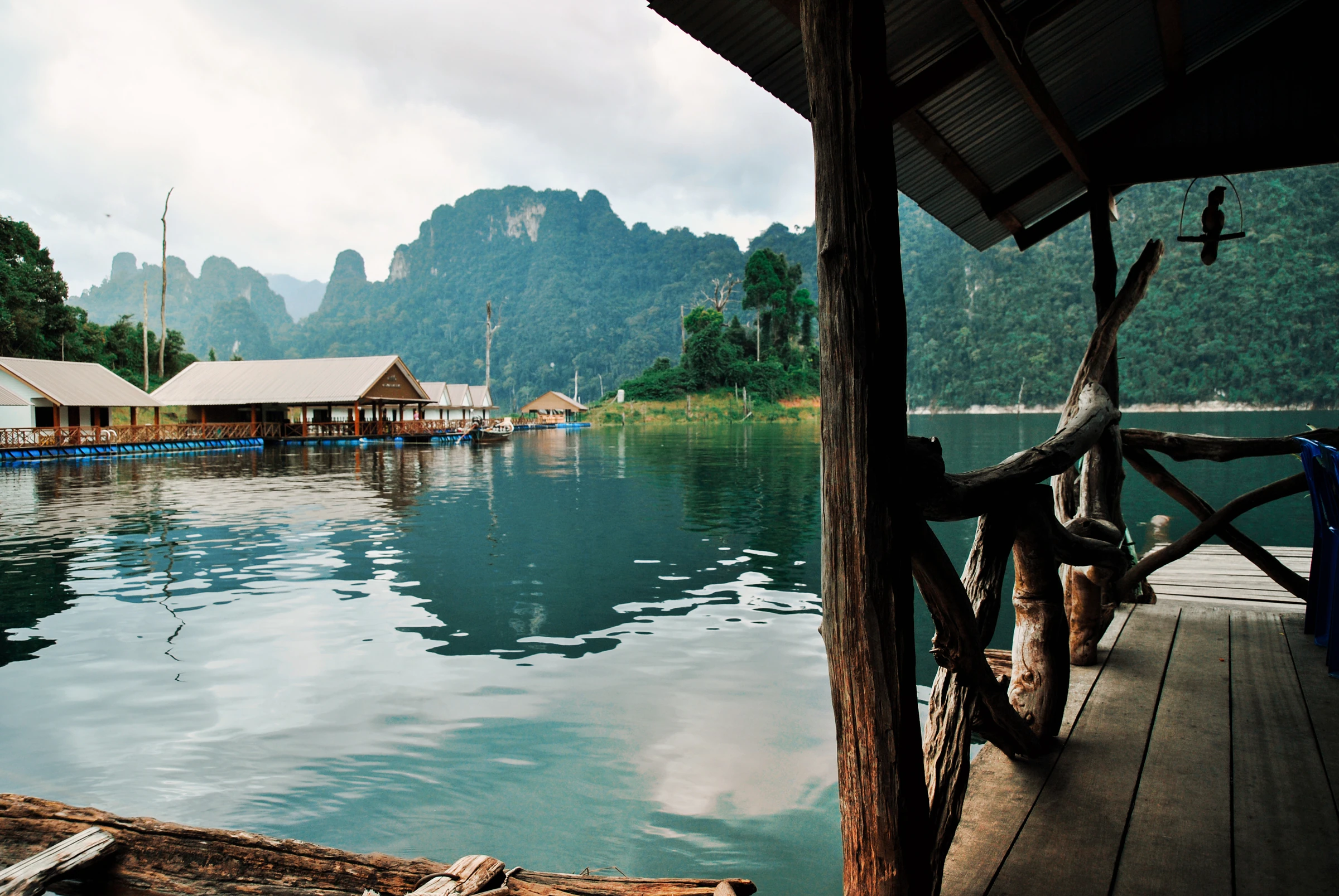 A floating raft house moored beneath limestone cliffs on Cheow Lan Lake at Khao Sok
