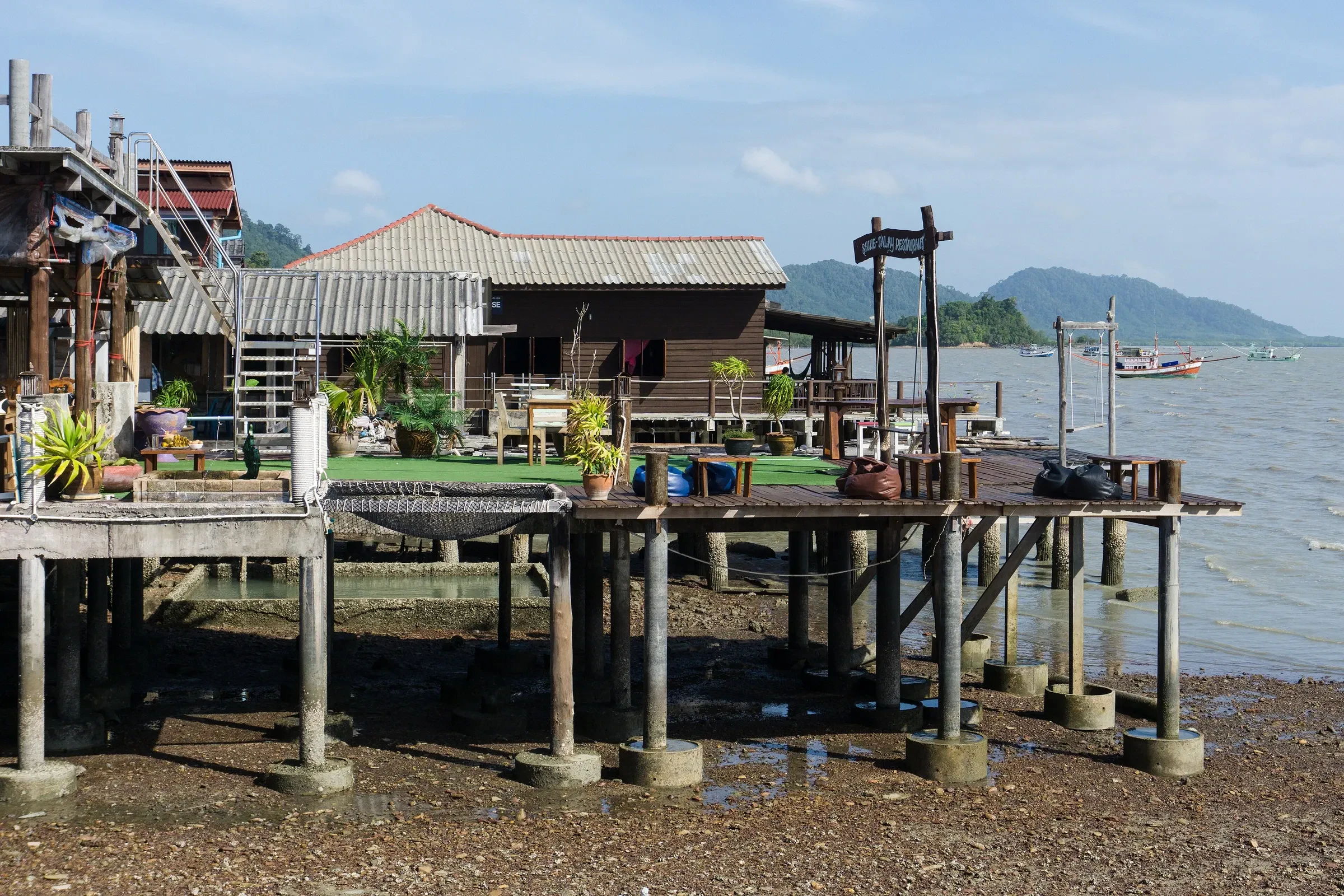 Wooden stilt houses over the water at low tide in Lanta Old Town, Koh Lanta