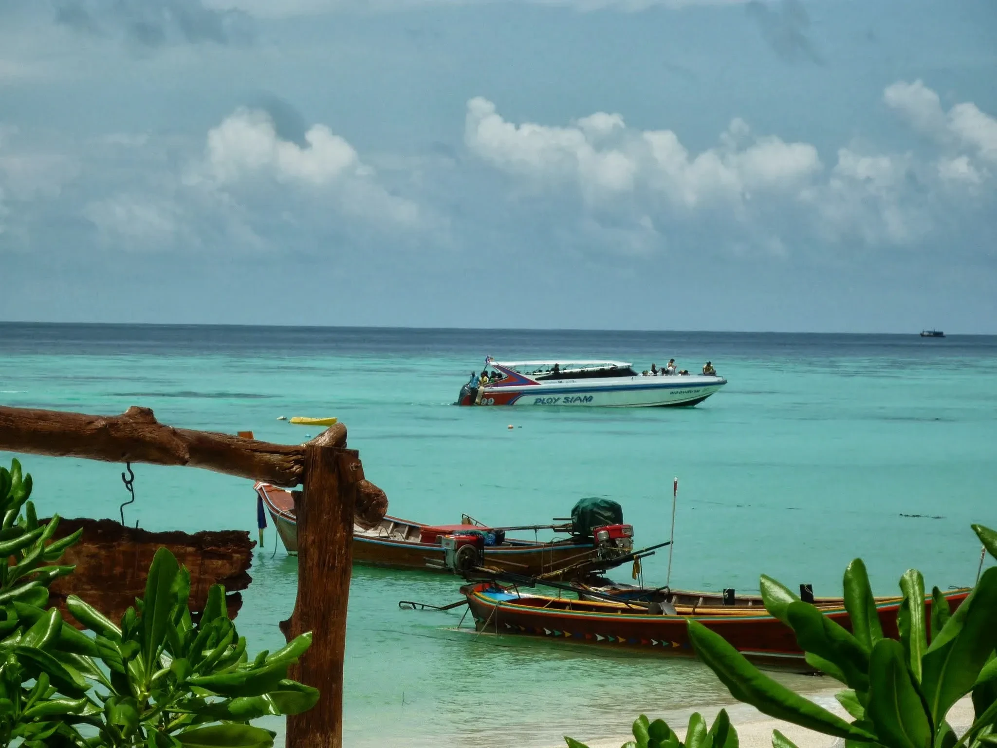 Longtail boats and a speedboat on turquoise water off Koh Lipe