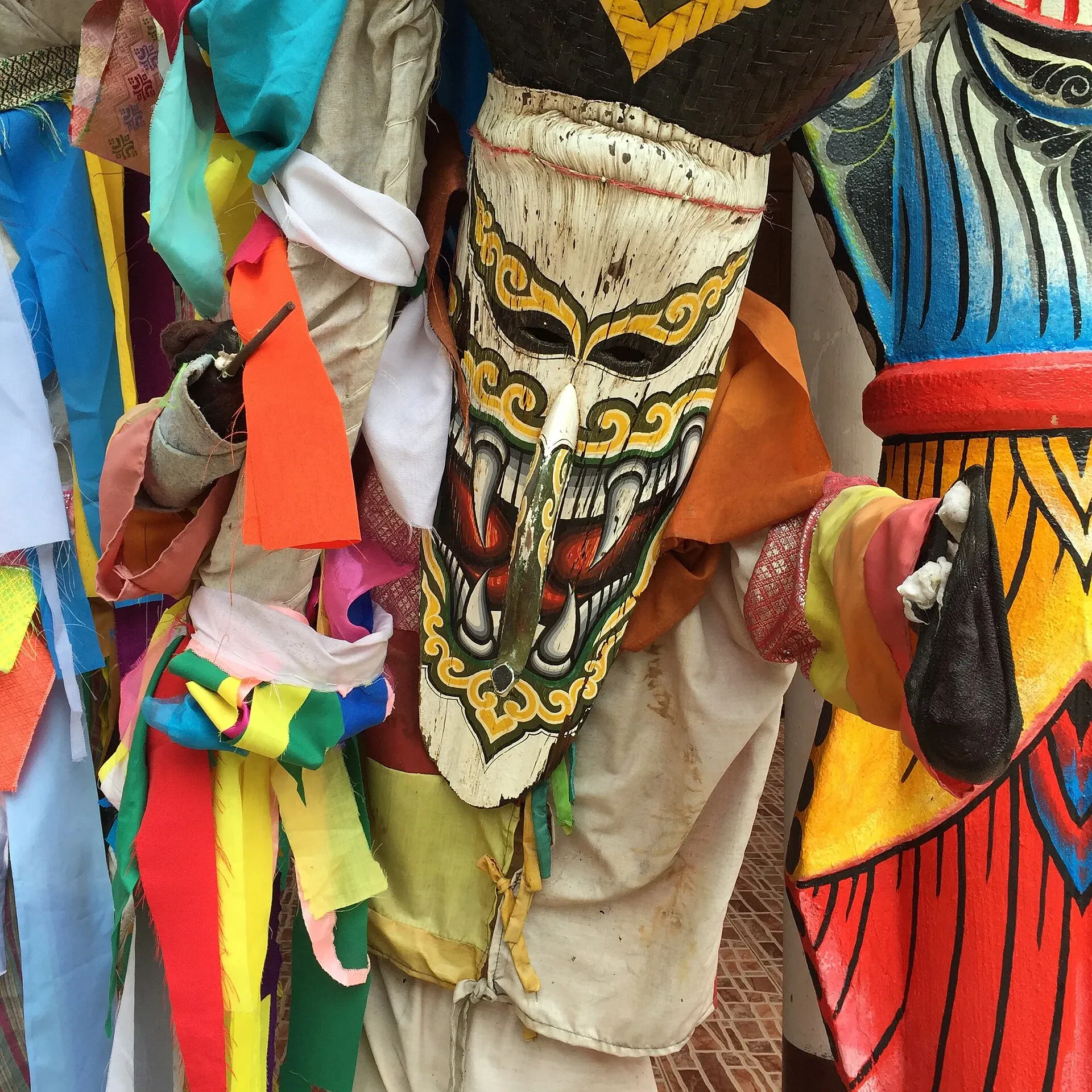 A Phi Ta Khon ghost in a mask and colourful rag costume in Dan Sai